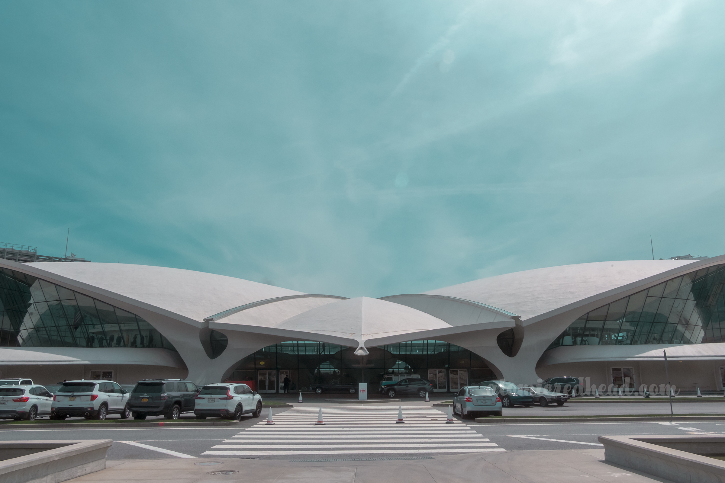 Exterior of the TWA Hotel, that looks almost as if it is about to lift off with arched wings.