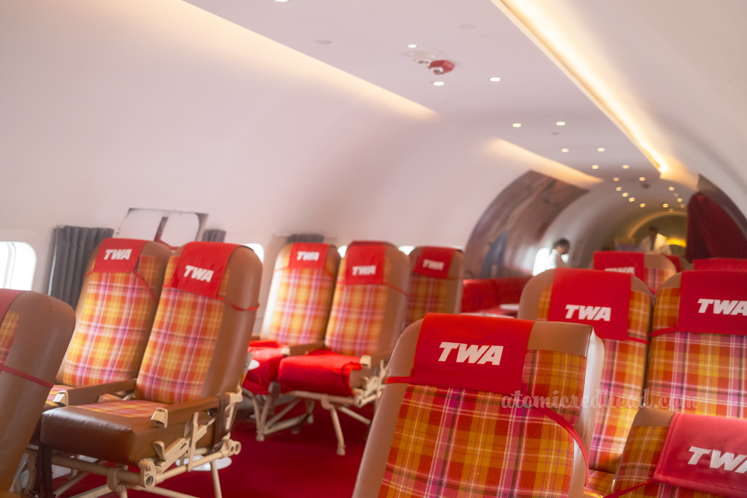 Brown seats with gold and red plaid upholstery in the center allow for visitors of the Connie to experience old air travel.