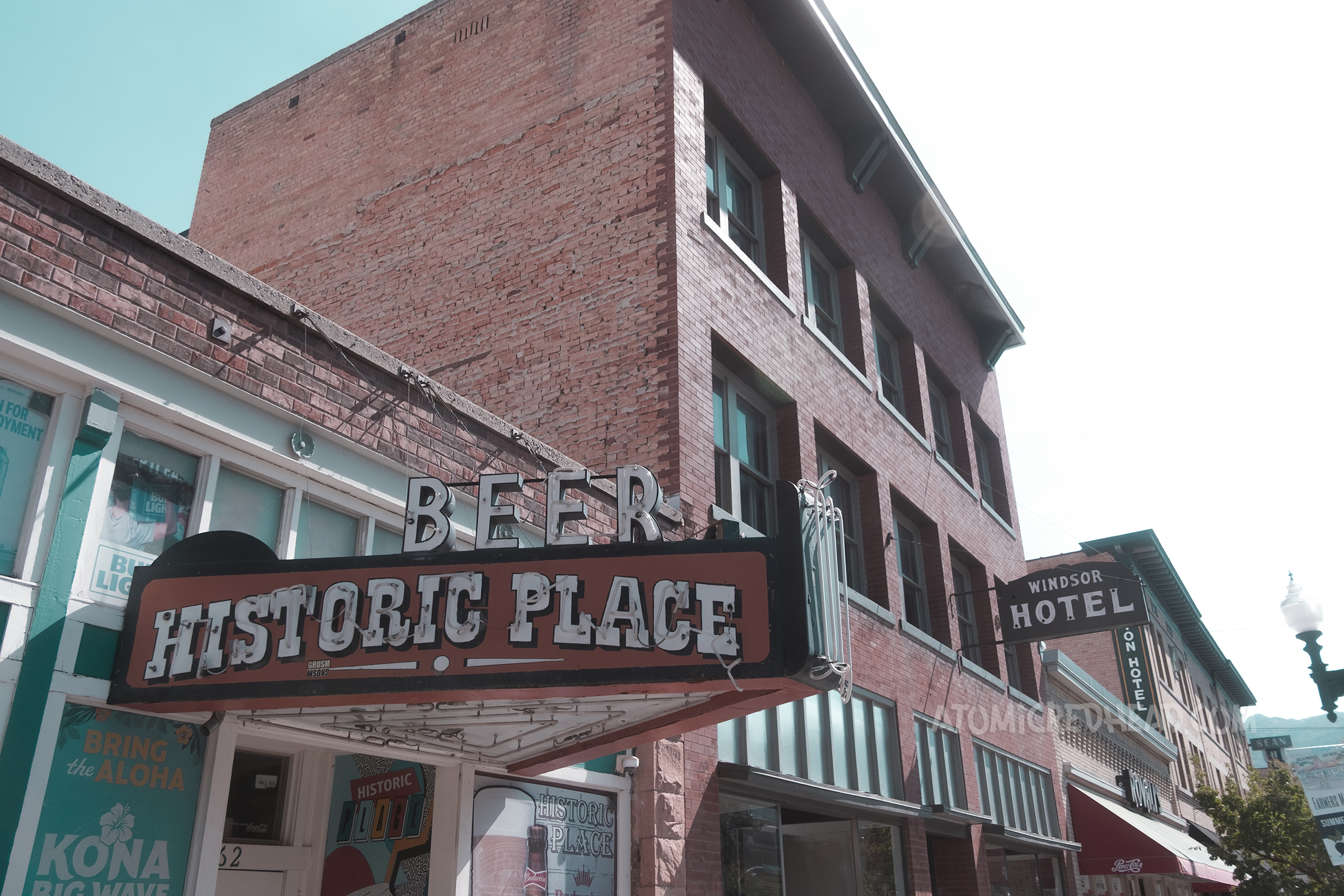 A neon sign hangs over a doorway and reads "Beer Historic Place"