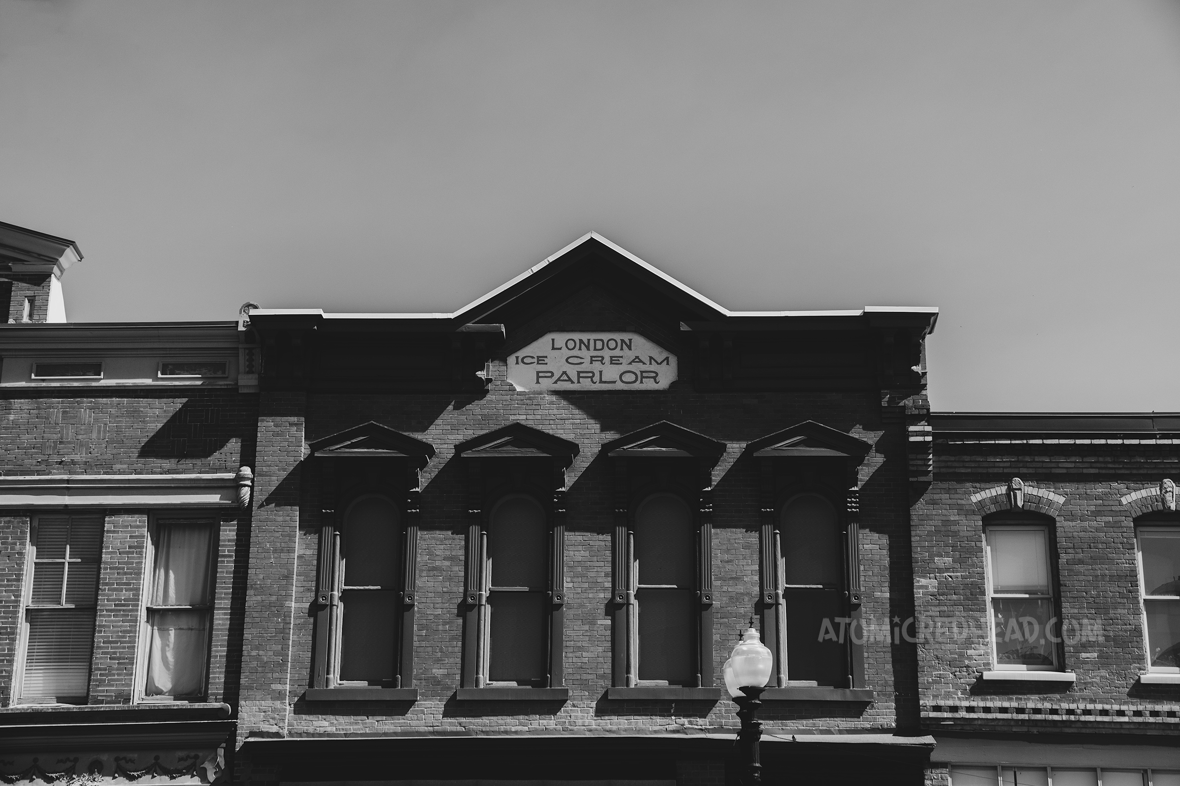A black and white image of a brick building that reads "Landon Ice Cream Parlor"