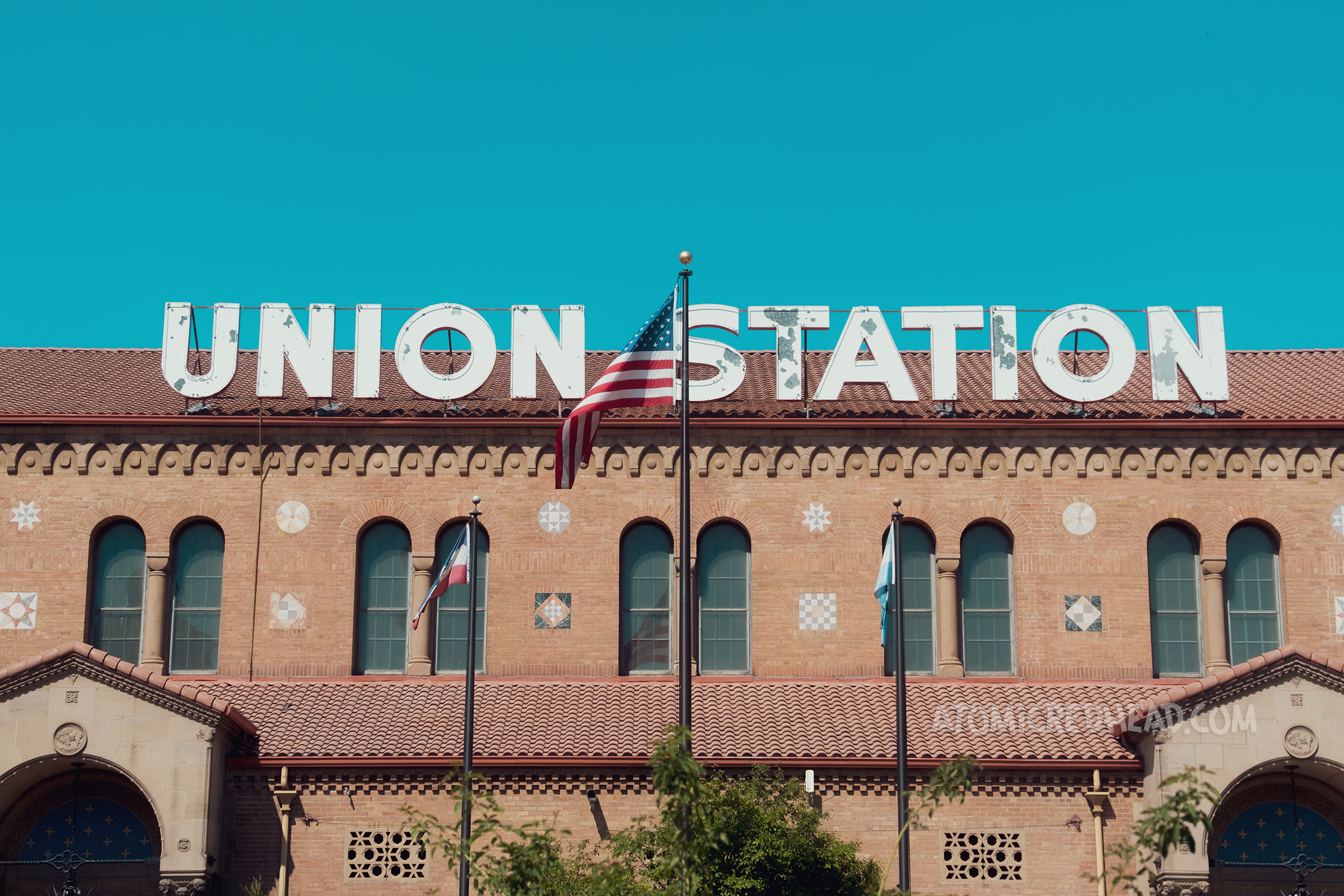 A large brick train station with massive white neon letters across the roof that read "Union Station"