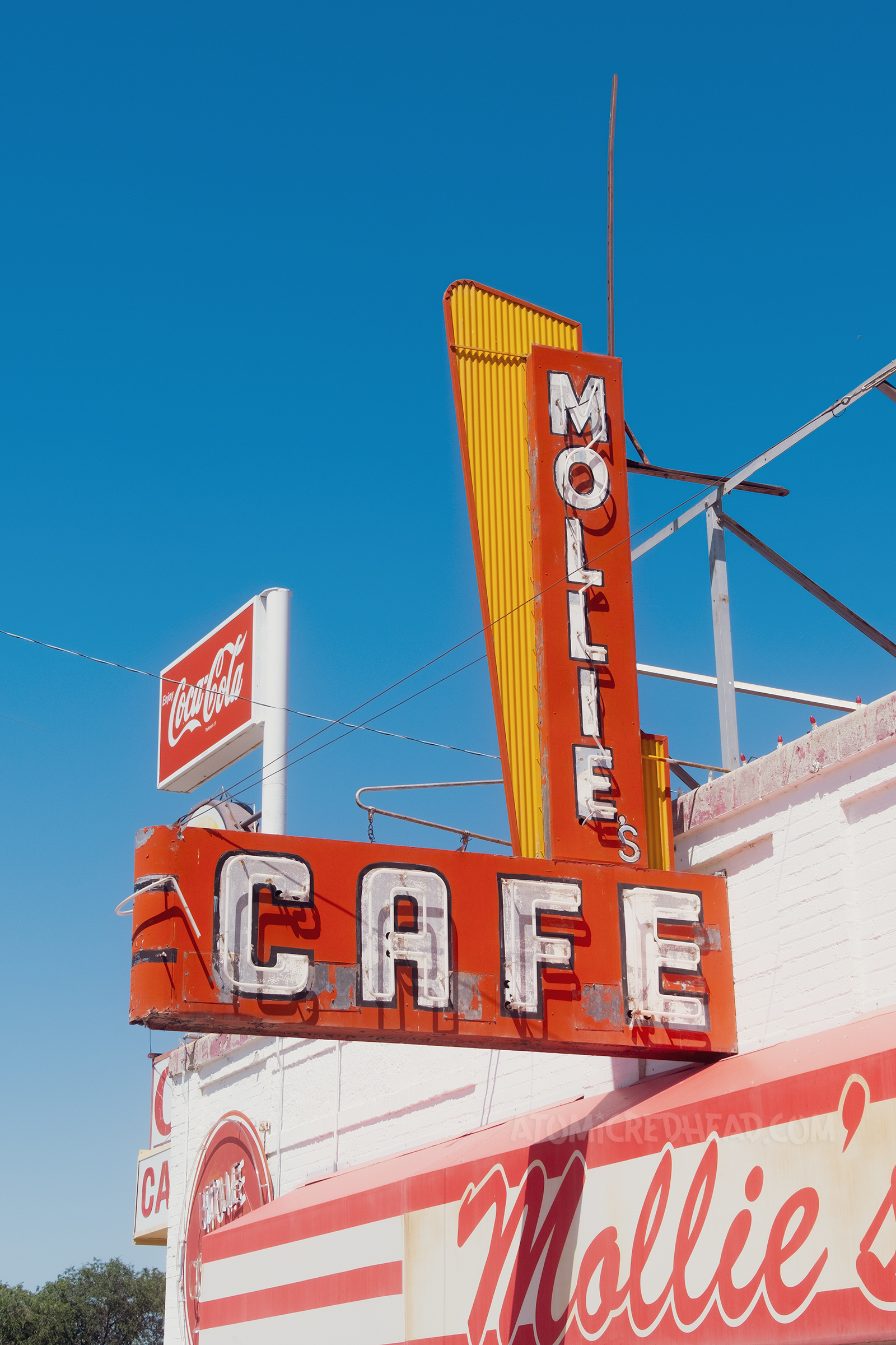 A red, yellow, and white blade style neon sign reads "Mollie Cafe"