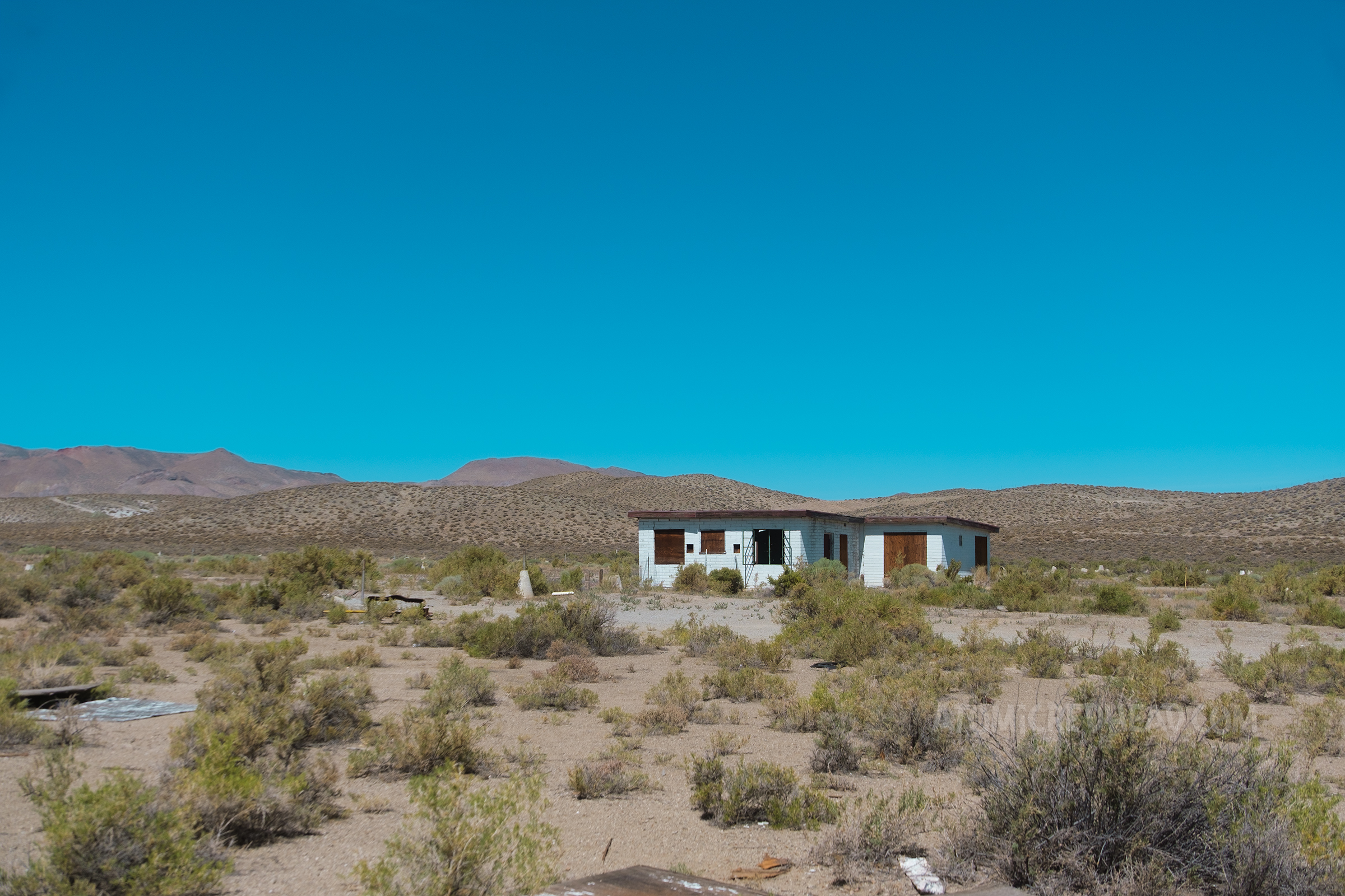 The small concession stand of the drive in sits amid overgrown grass.