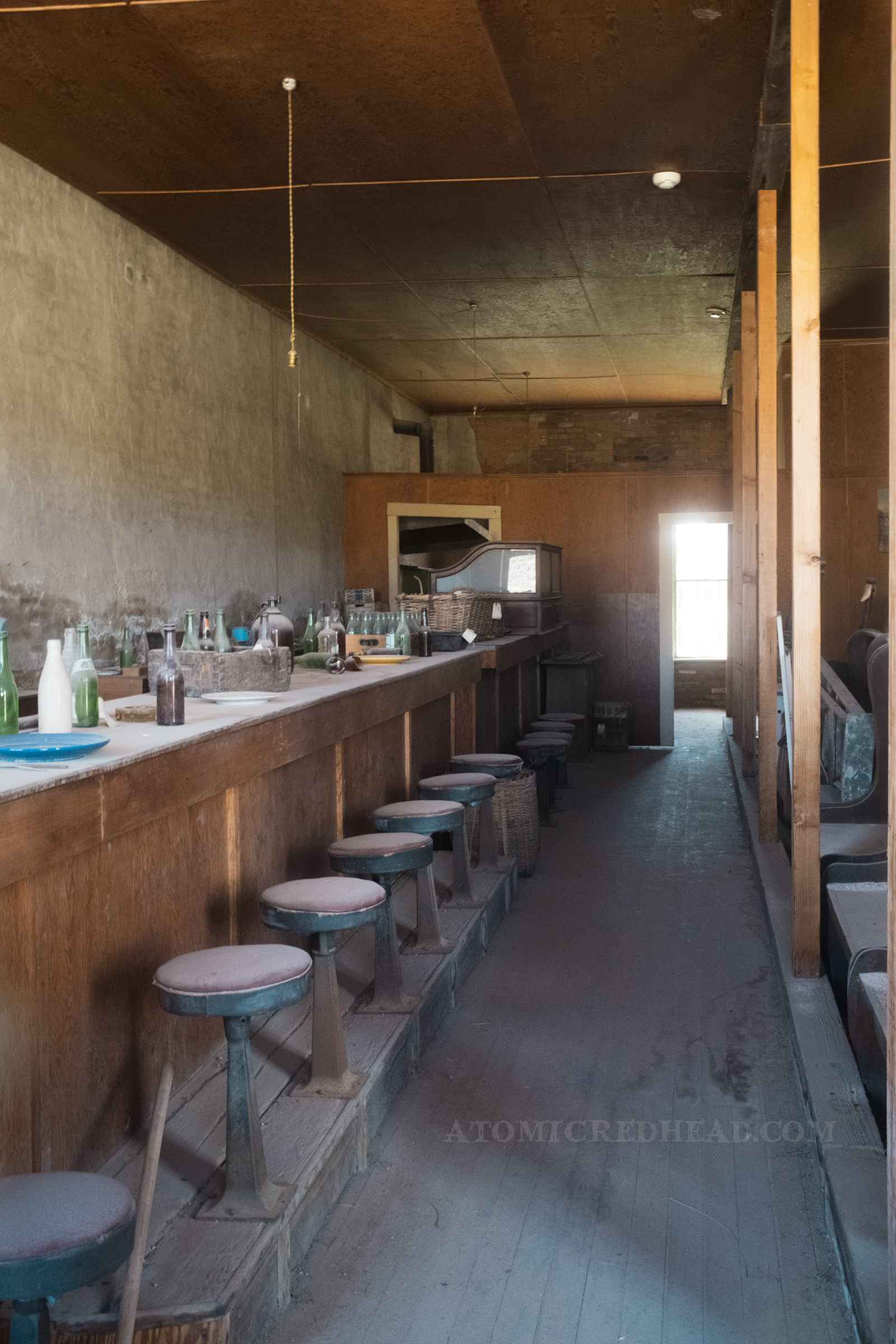 Inside the old Dechambeau Hotel with a long bar and stools.