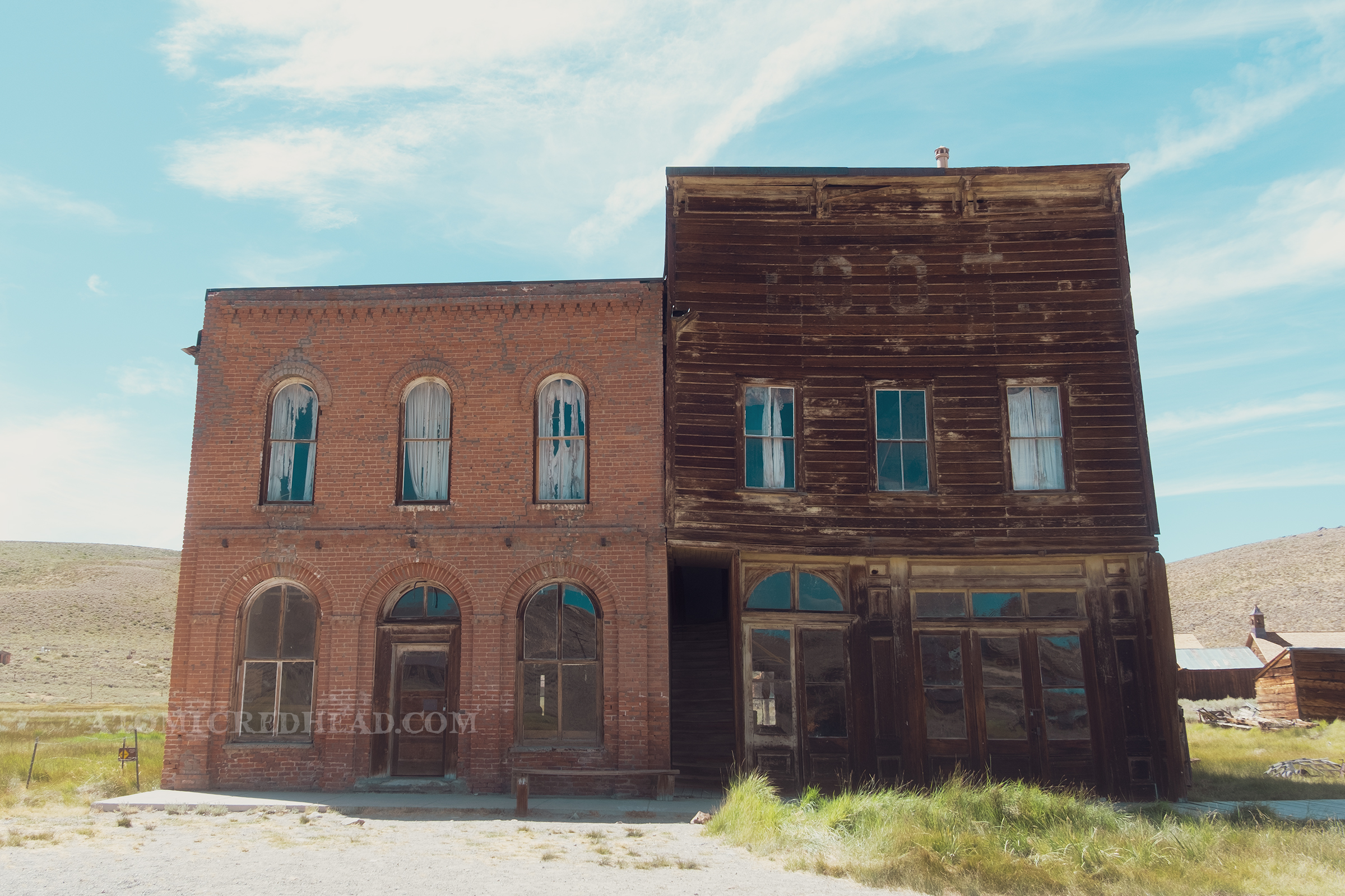 A two story brick structure, the old Dechambeau Hotel sits next to a two story wooden building, the former IOOF hall.