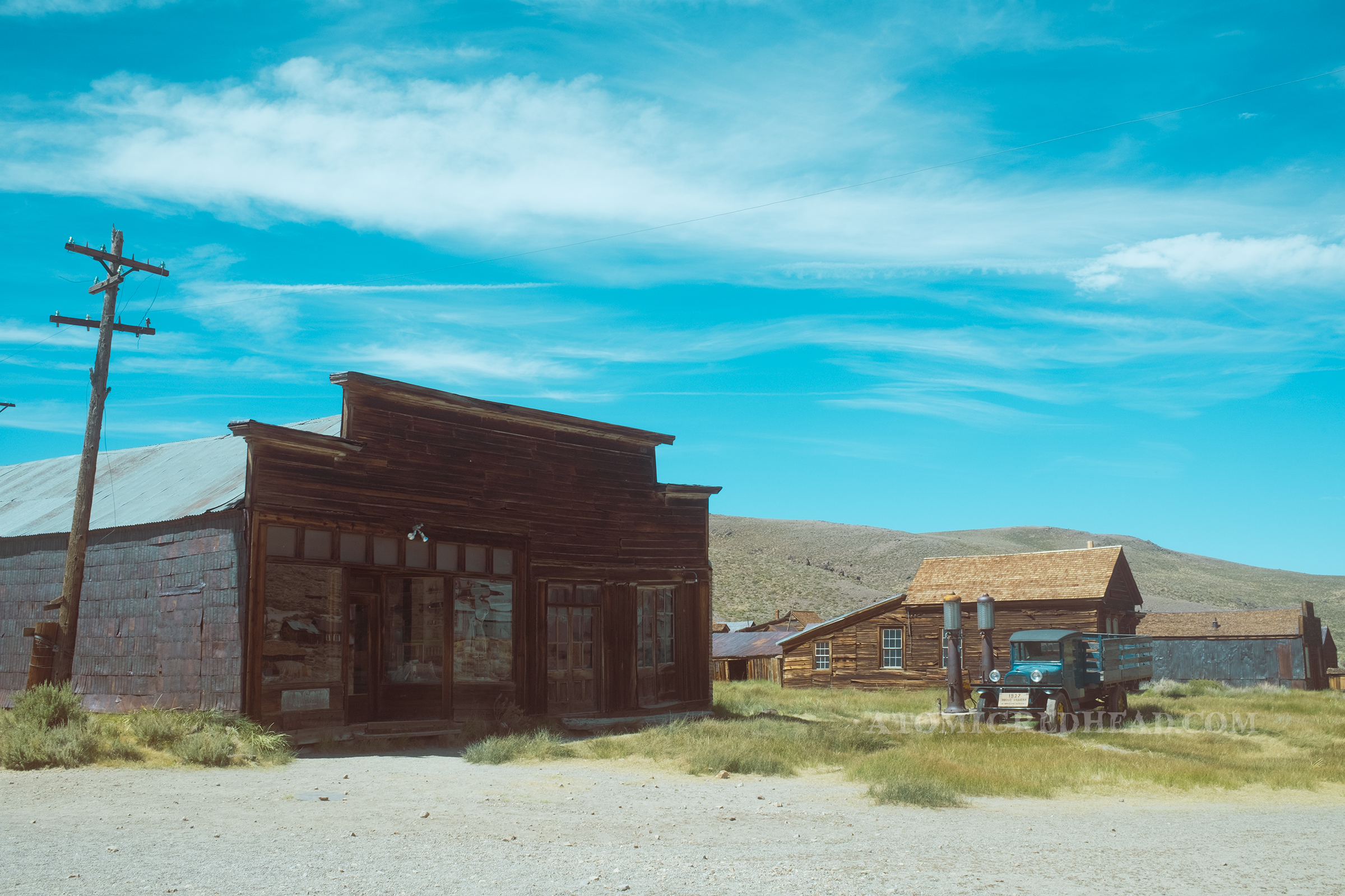 A larger wooden structure sits next to two gas pumps and an old pick-up truck. The building was once the Boone Store and Warehouse