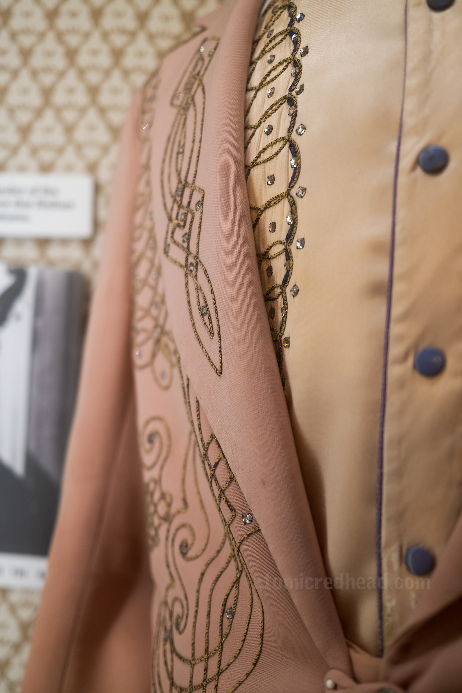 Closeup of a pink suit with gold trim, worn by Fred Maddox of Maddox Brothers and Rose, made by Nathan Turk,