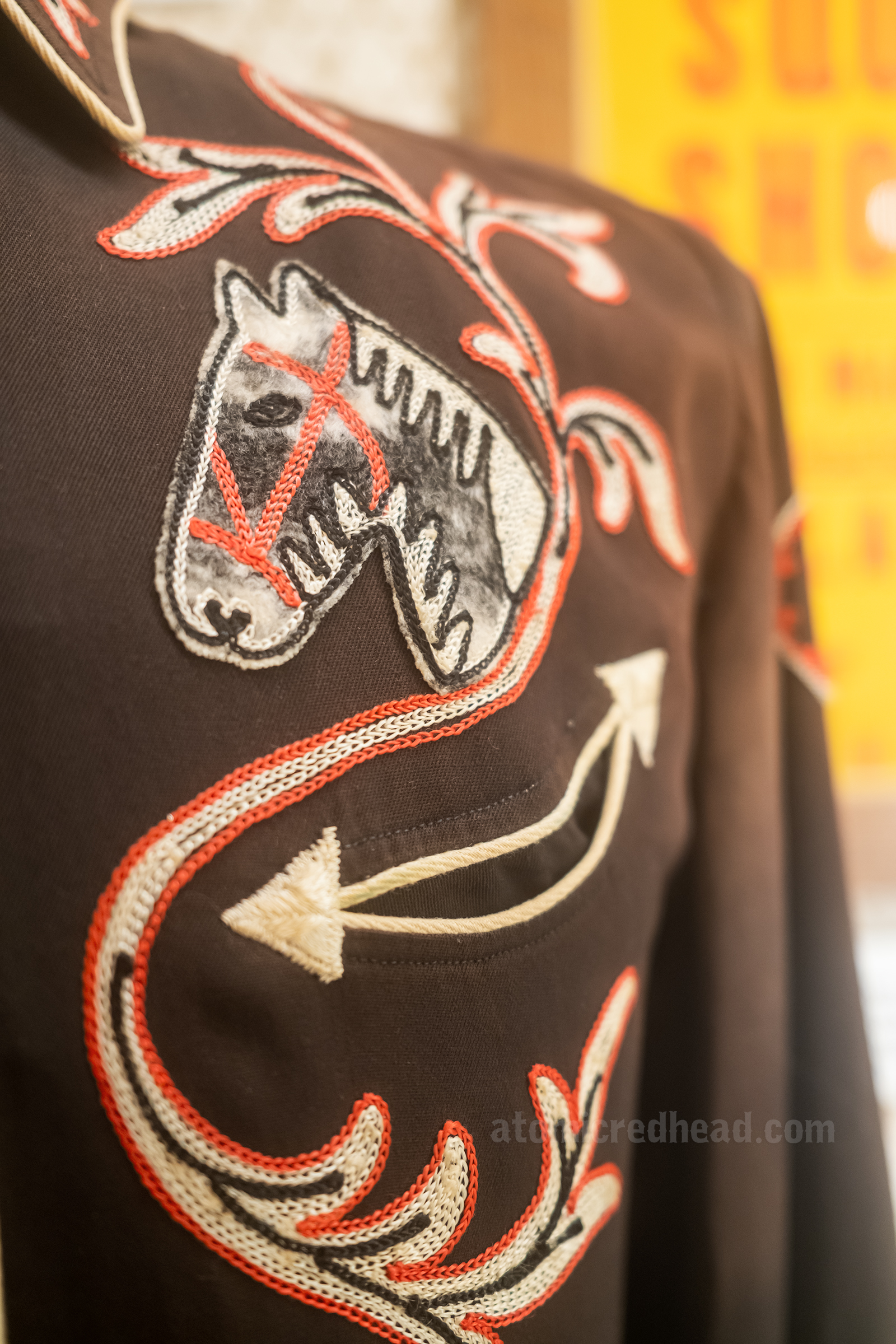 Closeup of an embroidered horse head on a black western shirt.