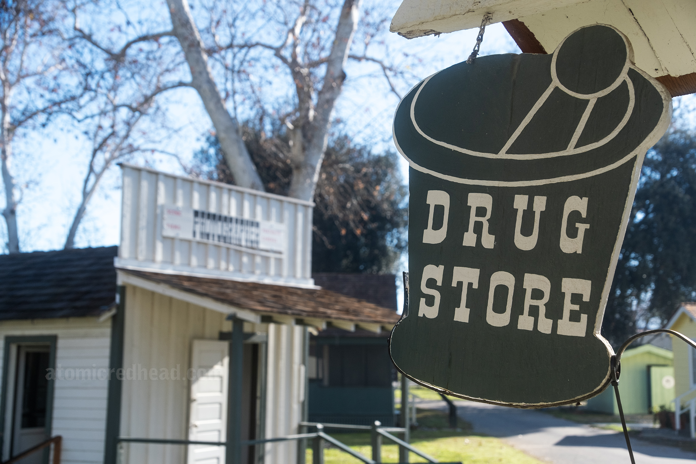 Close-up of a mortar and pestle sign reading "Drug Store"
