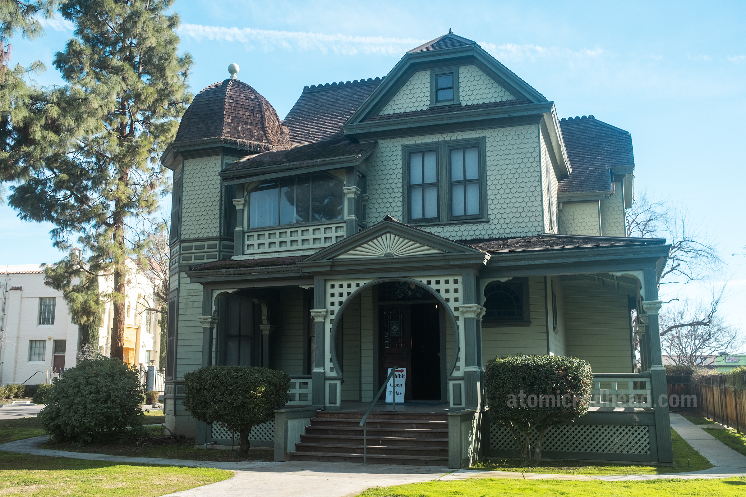 Exterior of the Howell home, a grand two story Victorian Queen Ann painted in light green with dark green trim.