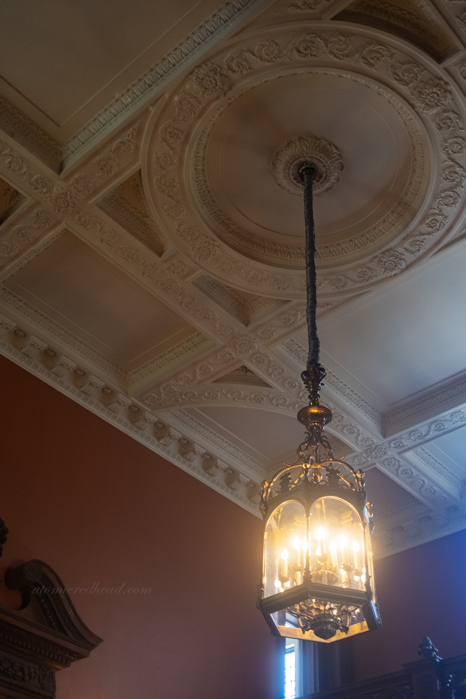 Close-up of the large light fixture, made of brass, hanging in the entry.