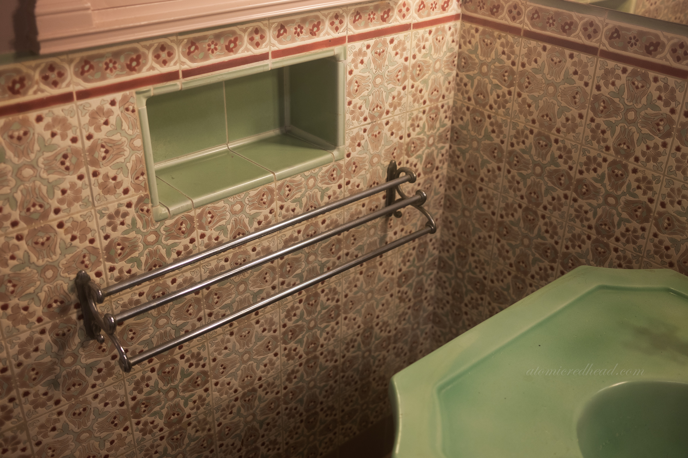 Lavish tile work in one of the bathrooms, done in pink, white, and pale green.