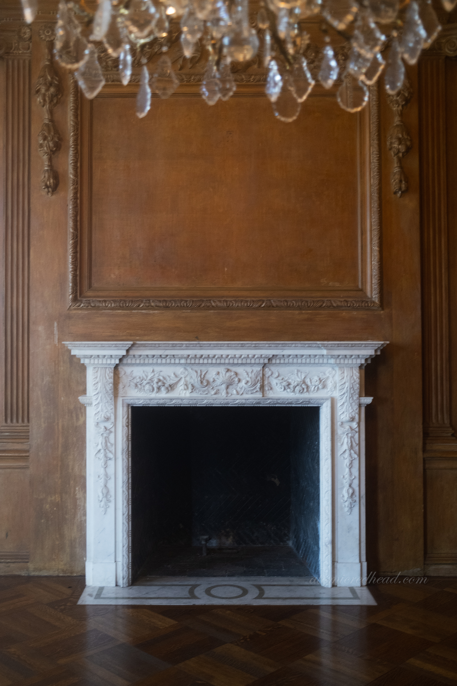 A white marble fireplace in the dining room.