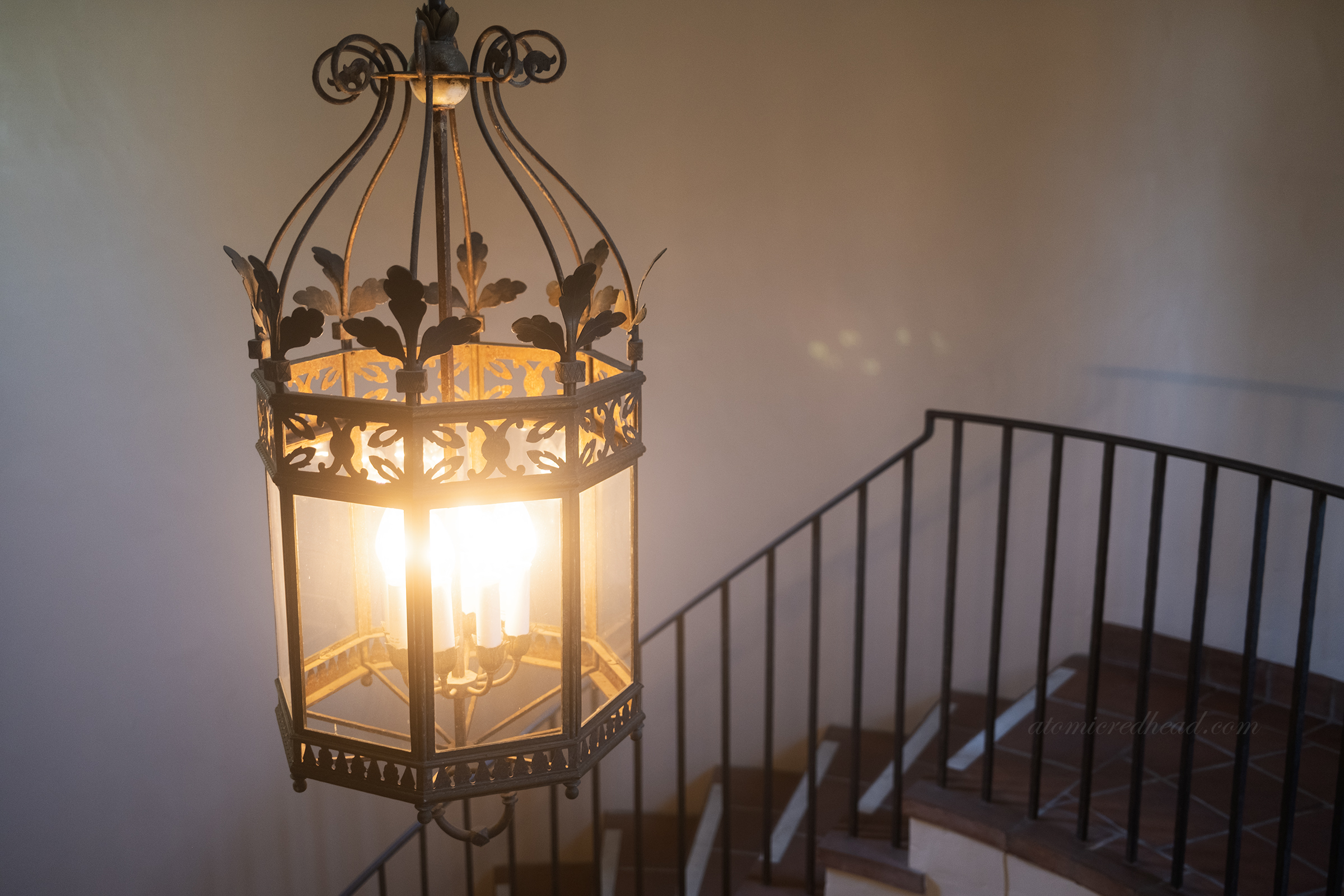 Close-up of a brass light figure hanging near the spiral staircase.