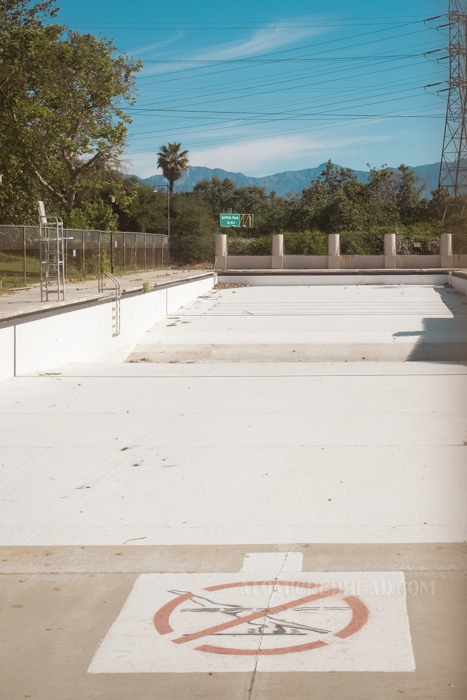 View of the expansive pool from one end, and a stencil indicating not to dive.