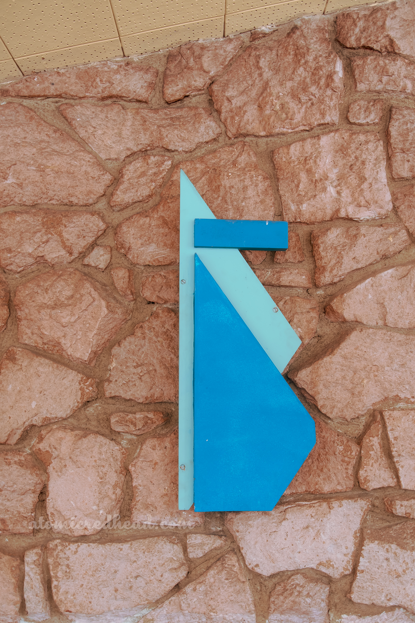 Close-up of a decorative piece hung on a rock wall.