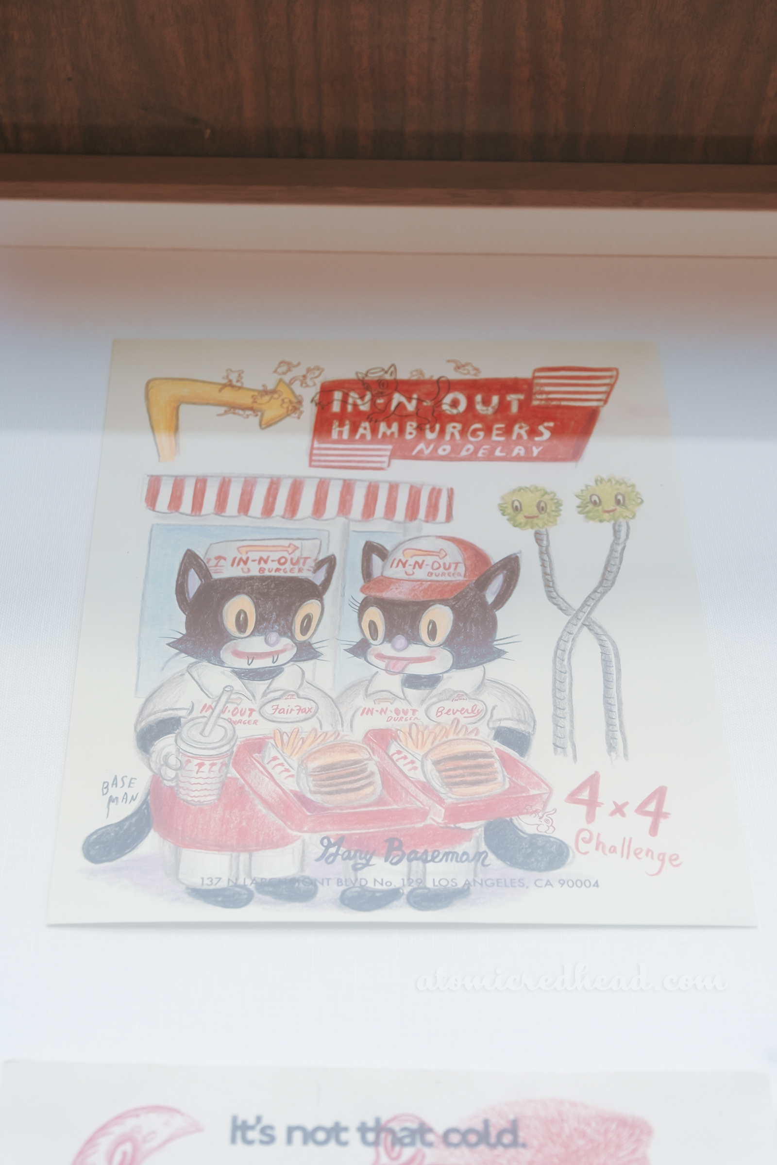 One of Baseman's works, this one features a pair of black cats working at In n Out.