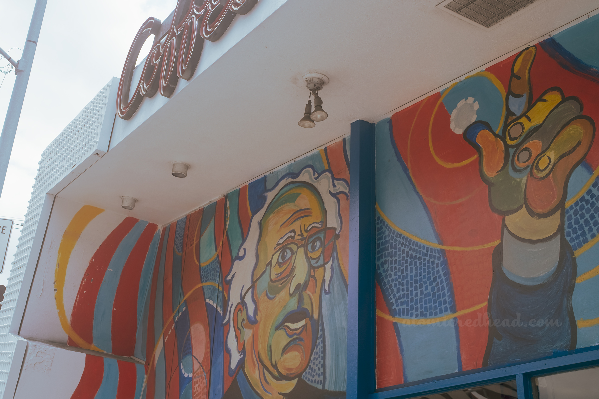 A large colorful mural of Bernie Sanders in the high windows of Johnie's.
