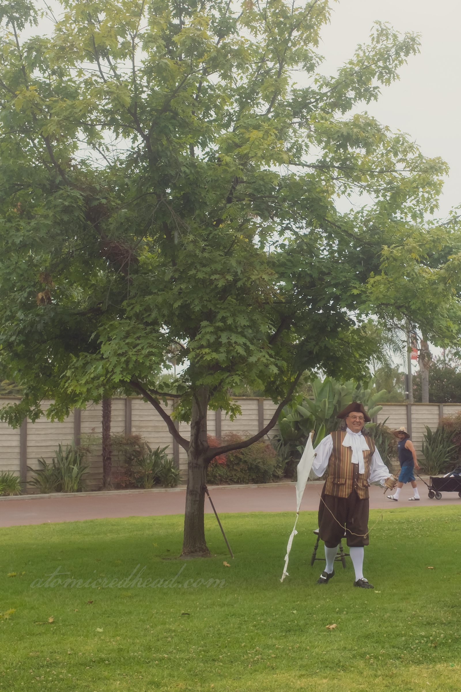 A reenactor of Ben Franklin holds a kite.