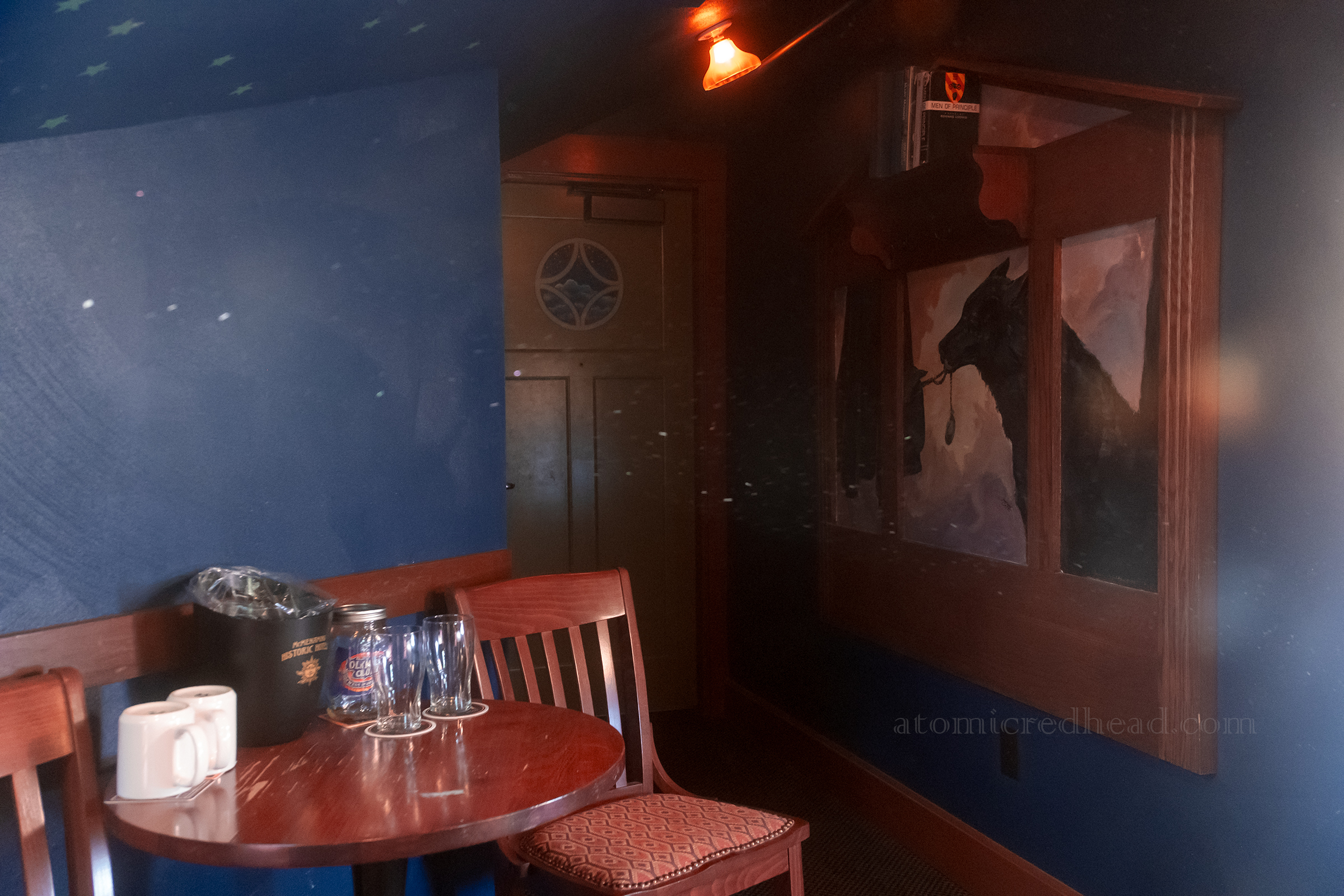 A wolf mural is painted on the right, with a seating area on the left.