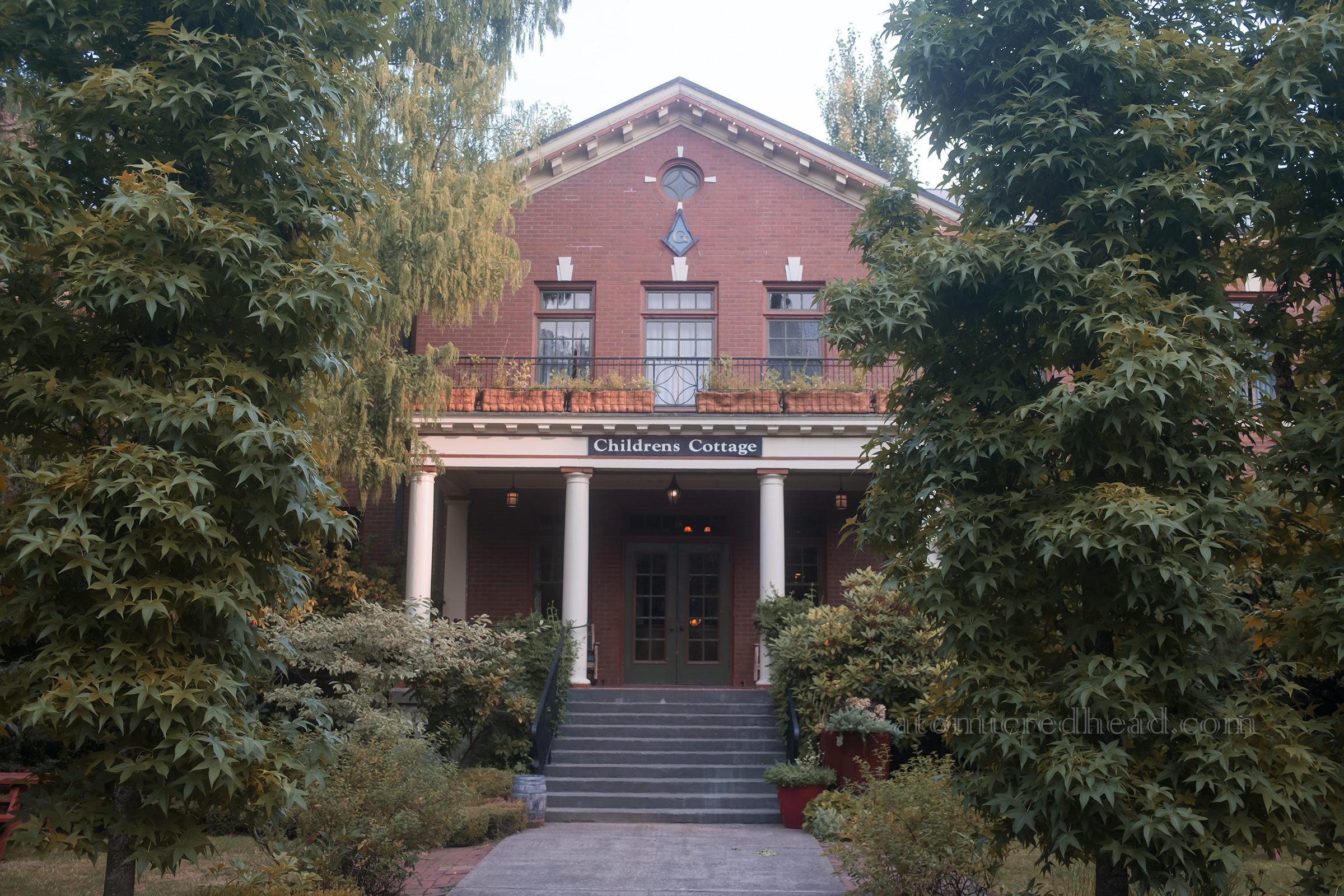 Exterior of the Children's Cottage, a smaller version of the first building, with smaller columns out front.