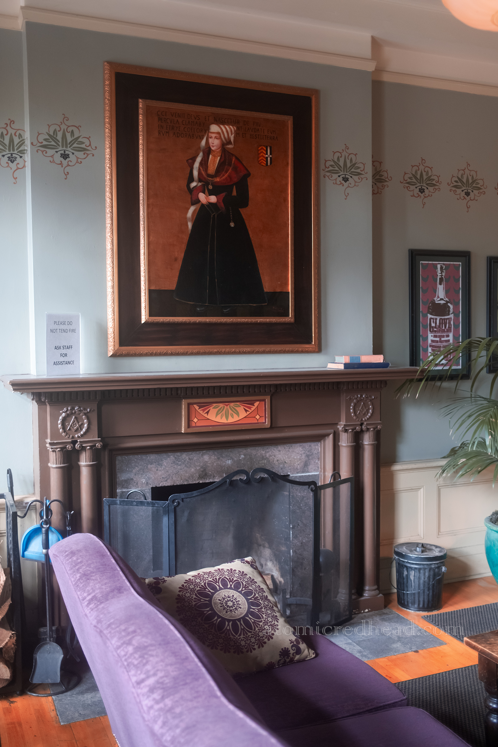 A woman's portrait hangs above a fireplace near the check in desk.