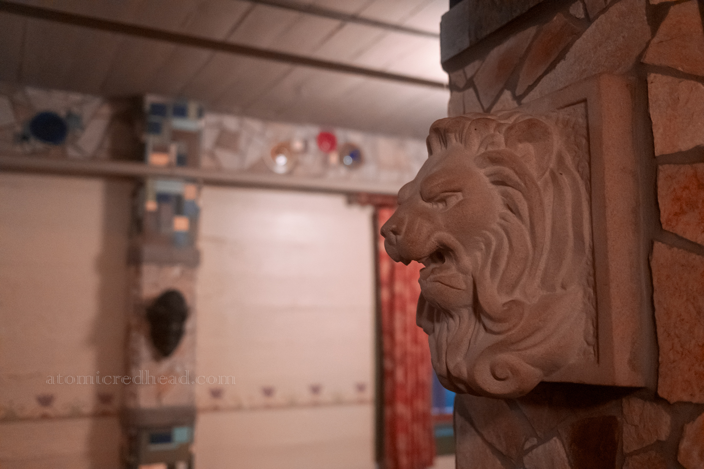 A stone lion head amid other mosaic works.