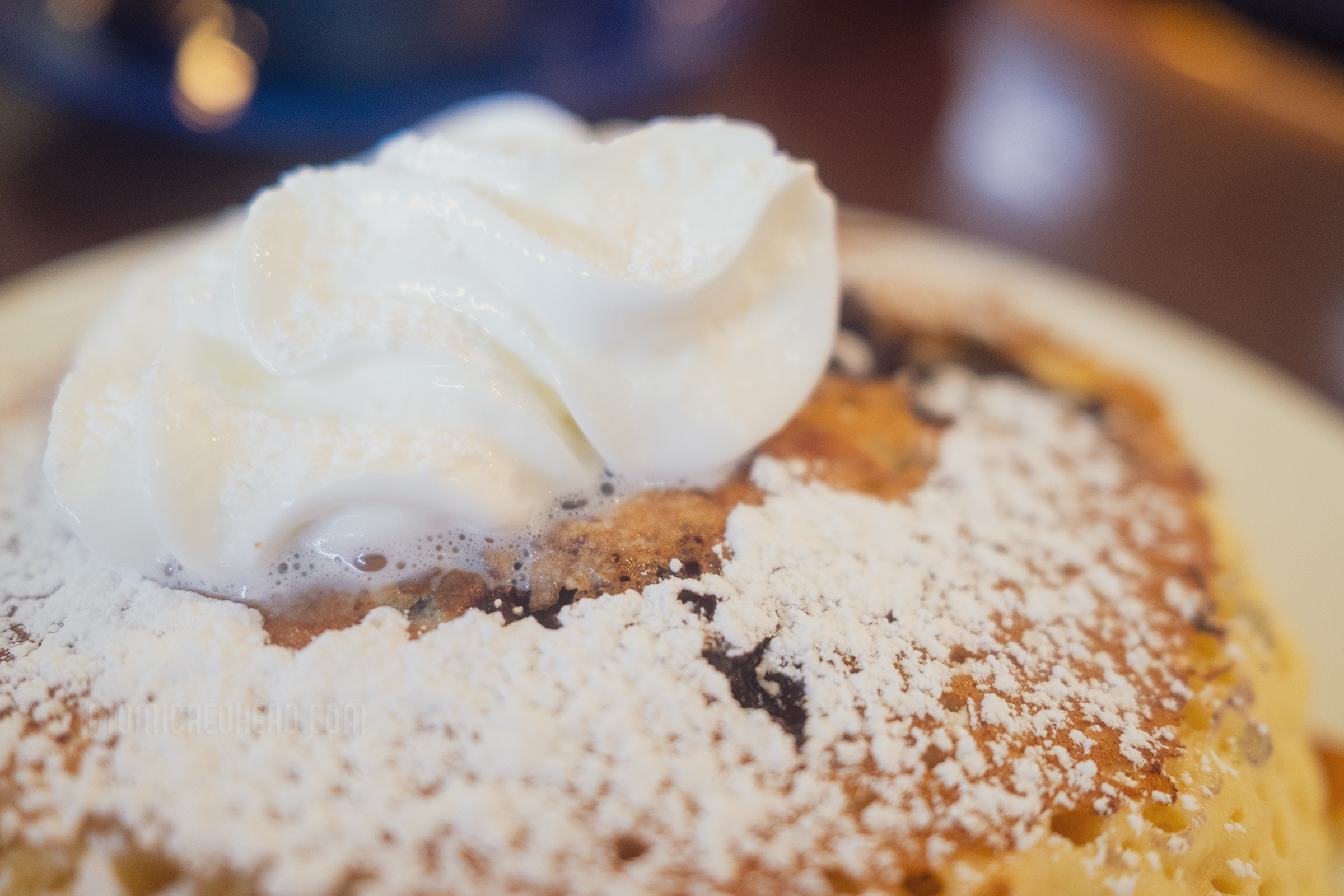 Close-up of blueberry pancakes with whipped cream.
