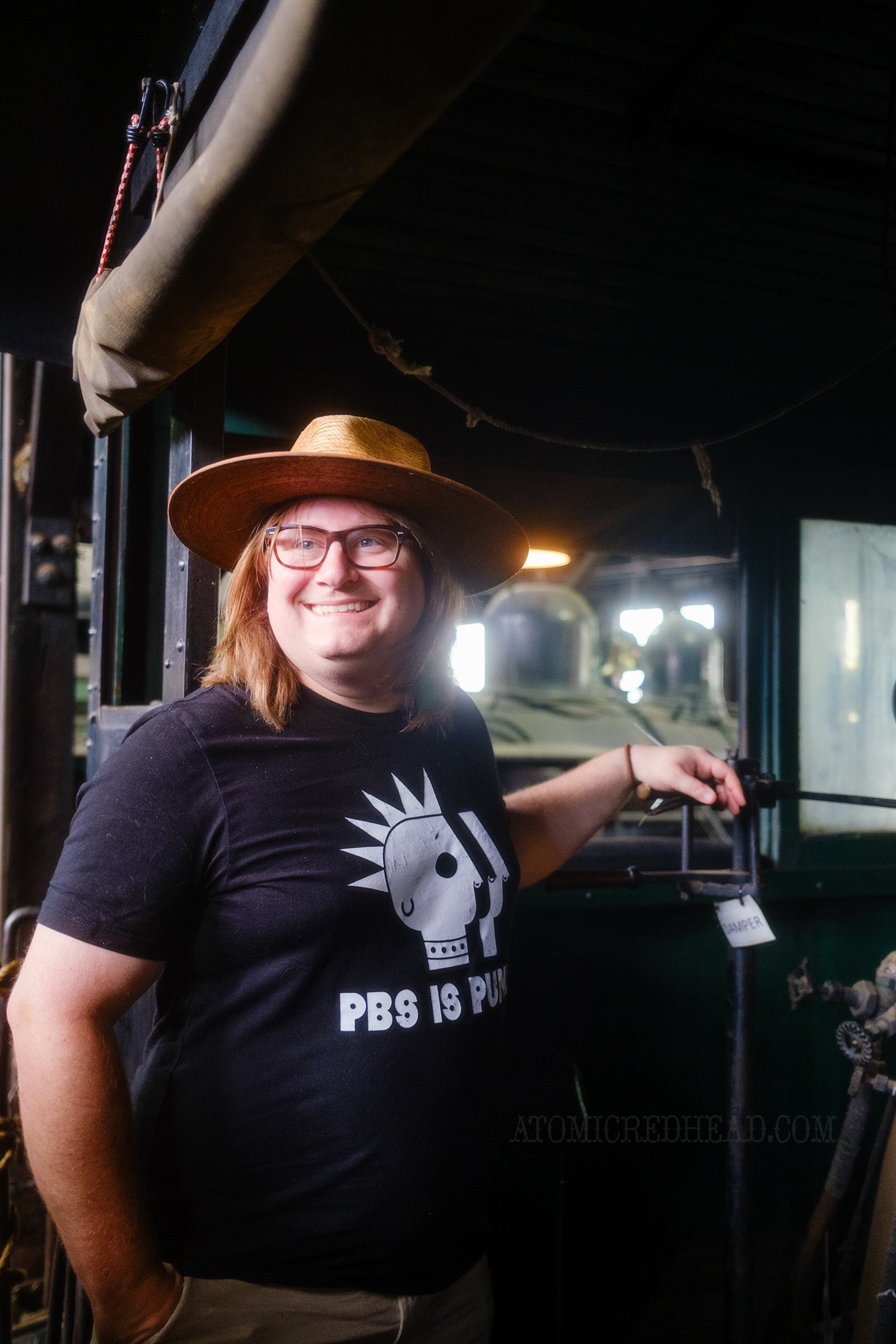 Patrick stands inside the cab of one of the engines.