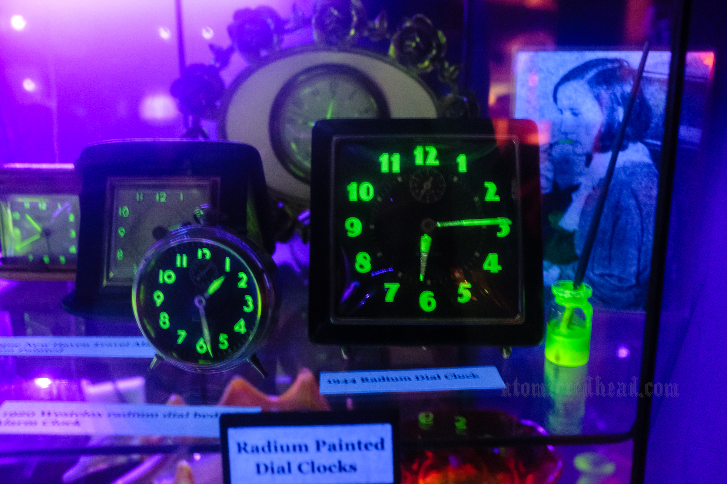 Multiple clocks that feature glowing green numbers on their face.