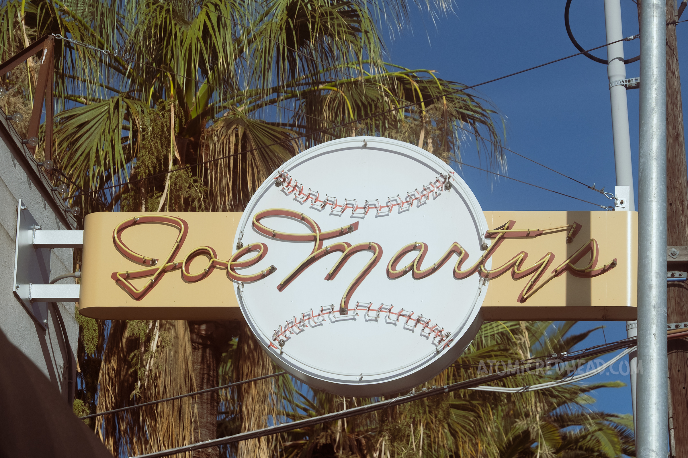 A neon sign with a large baseball and "Joe Marty's" in script.