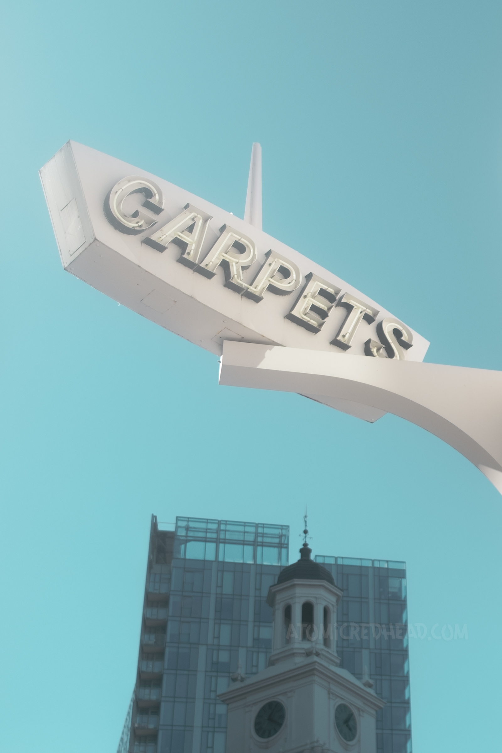 A space-age style neon sign reads "Carpets"