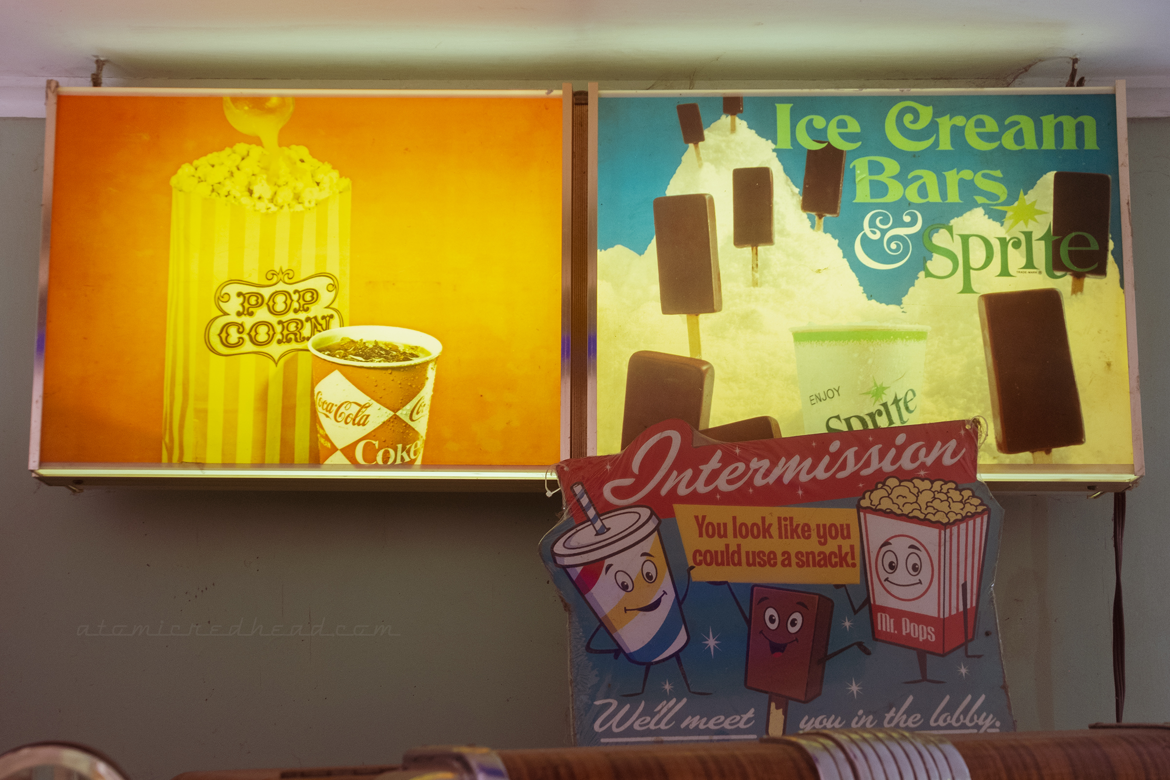 Lighted sign advertising popcorn and ice cream.