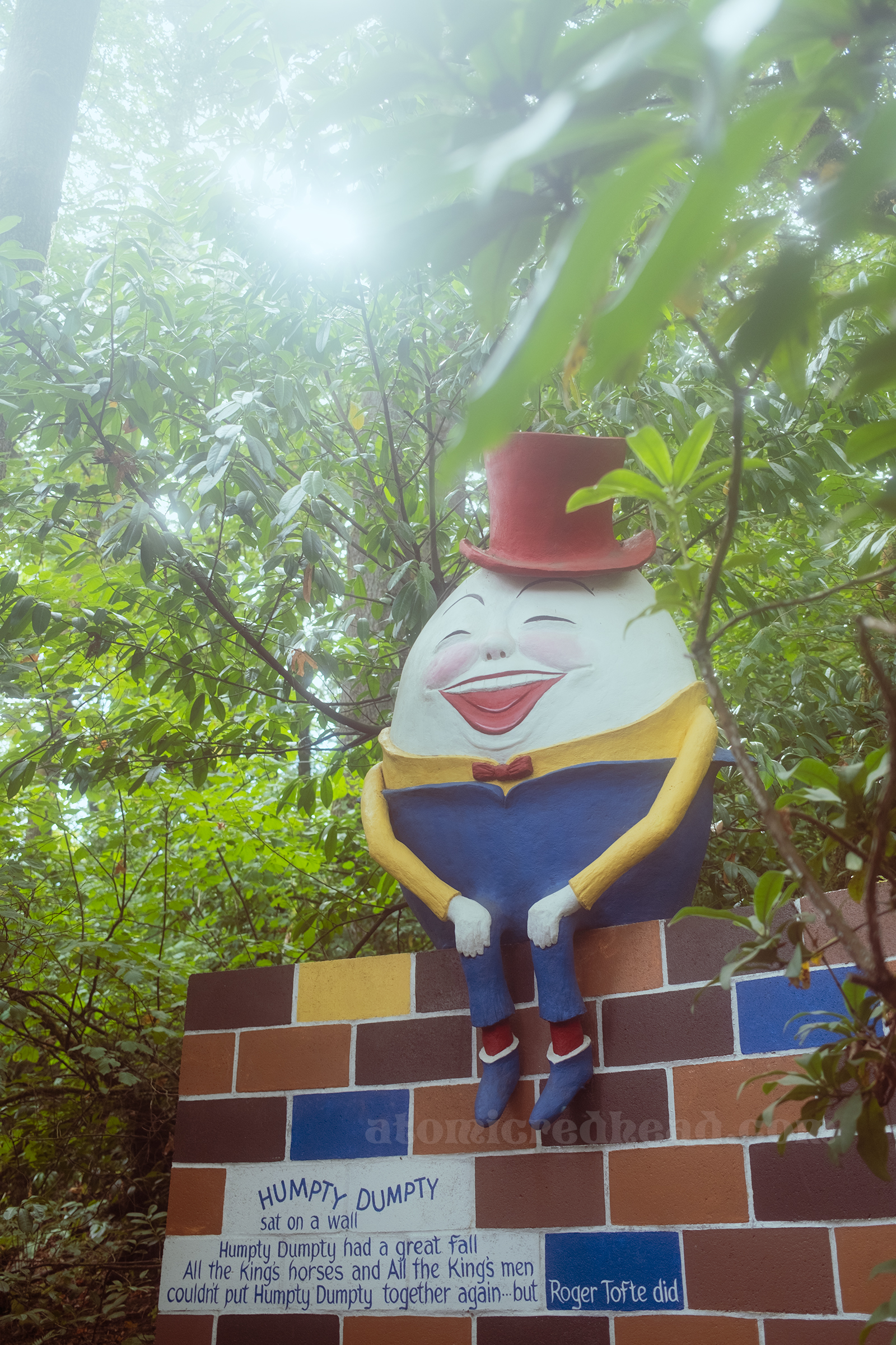 The egg character Humpty Dumpty dressed in a blue and yellow outfit with a red top hat sits on a brick wall. On the wall reads "Humpty Dumpty sat on a wall. Humpty Dumpty had a great fall. All the King's Horses and All the King's men couldn't put Humpty Dumpty together again...but Roger Tofte did"