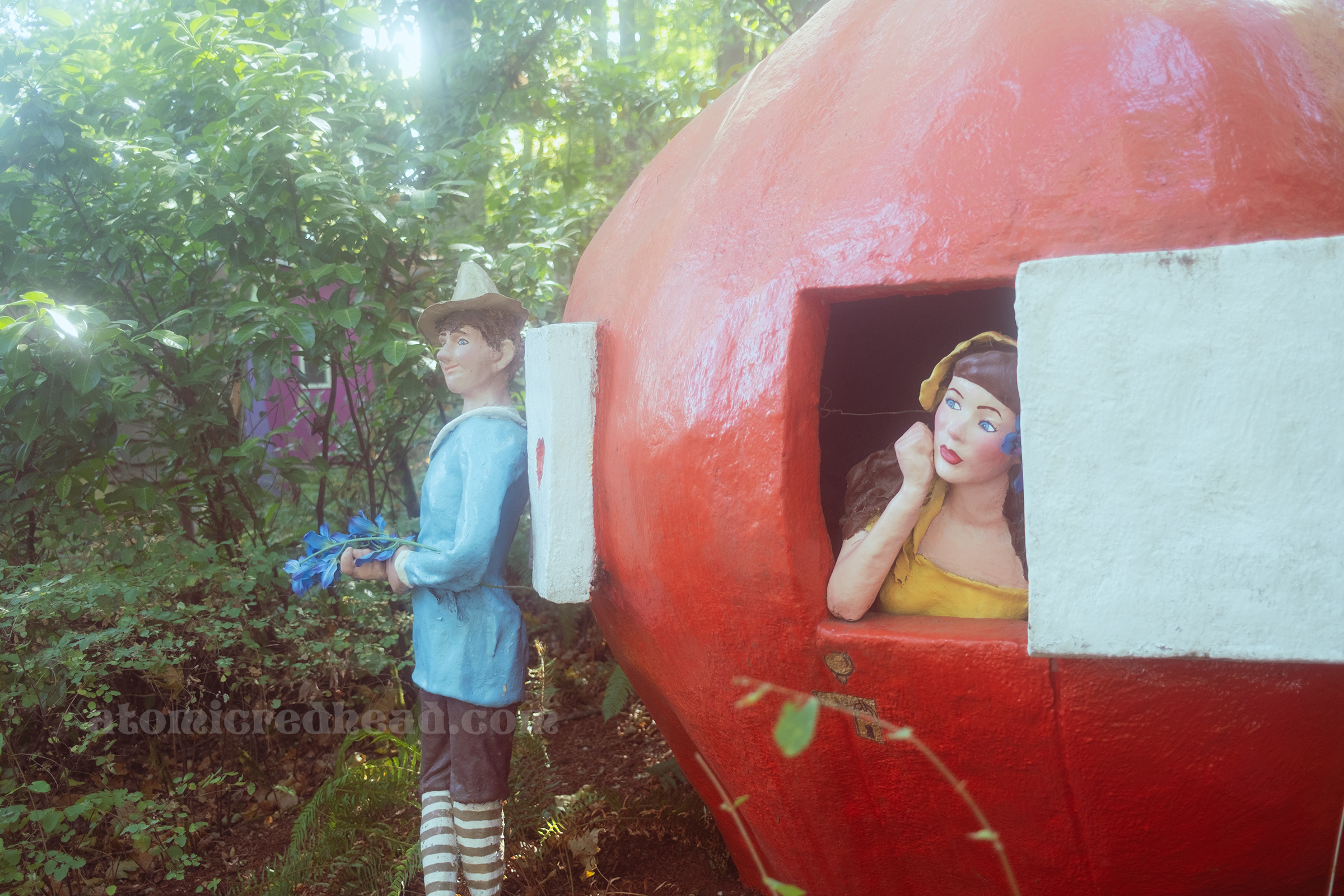 Peter Pumpkin Eater leans against a massive pumpkin house, through the window a woman looks out, wistfully.
