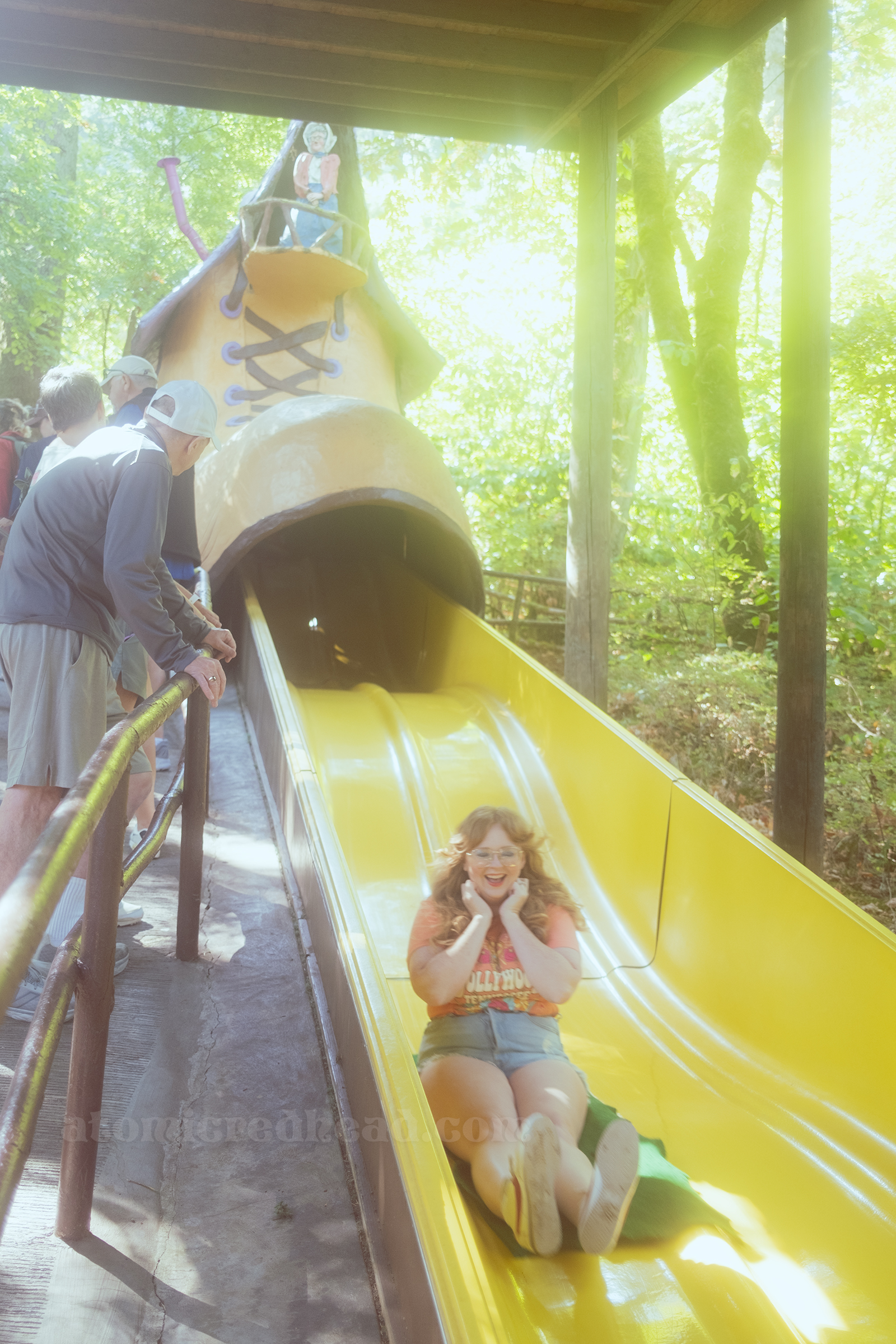 Myself coming down a large yellow slide from a massive shoe from the Old Woman in the Shoe story.