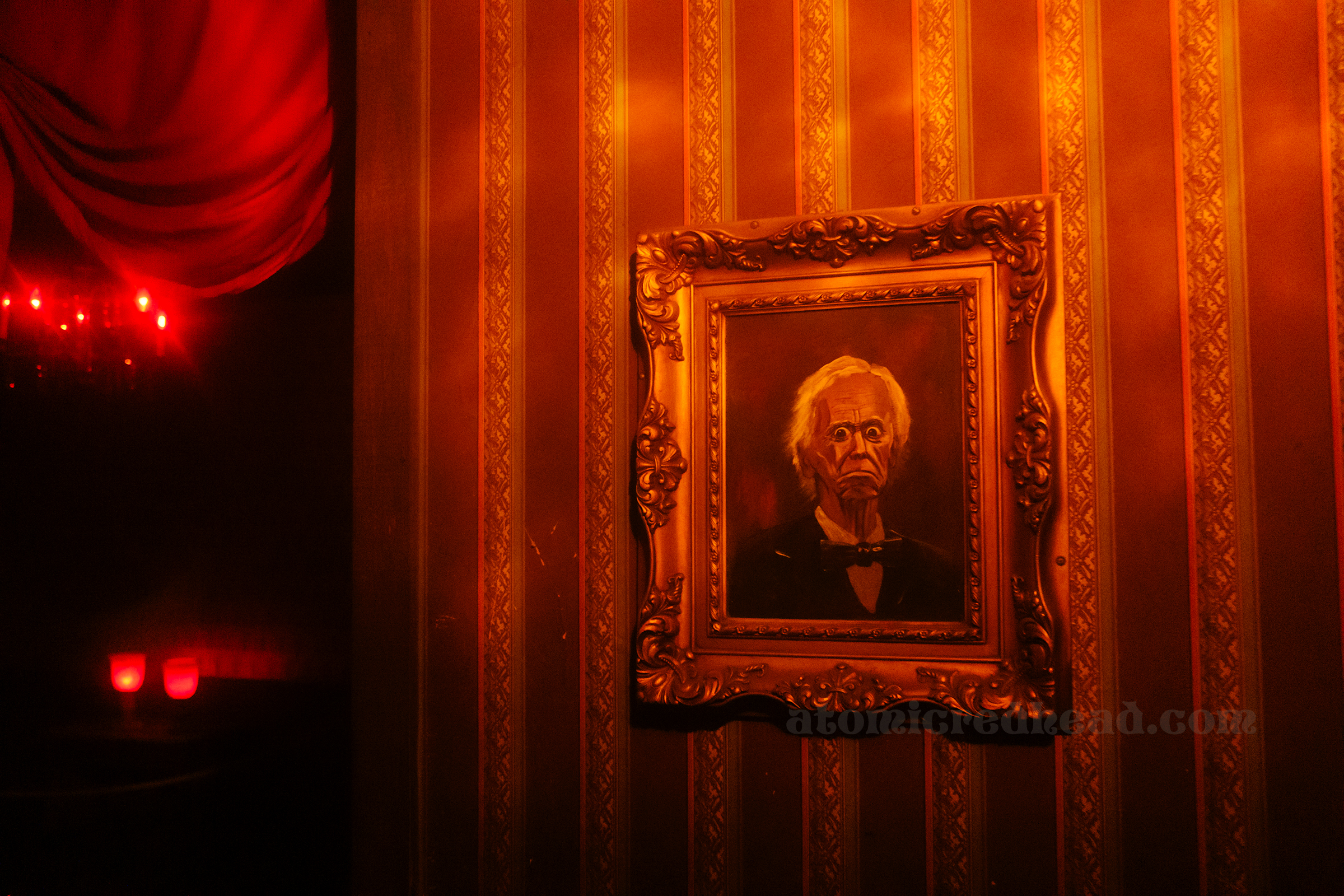 A painting of a creepy old man hangs on the wall in the Haunted House.