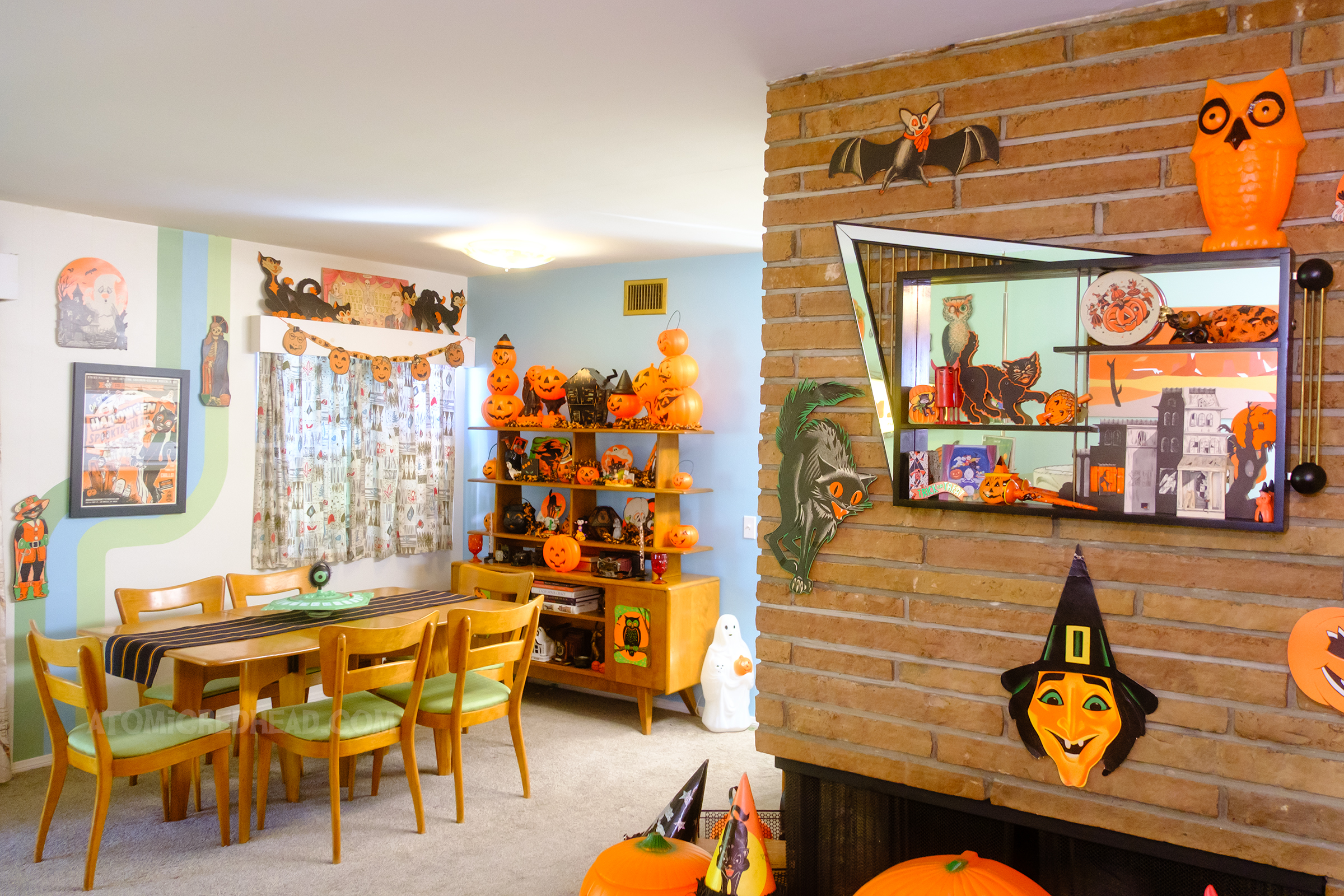 View into the living room, with our fireplace on the right, above it hangs a shadow box filled with vintage Halloween decor.