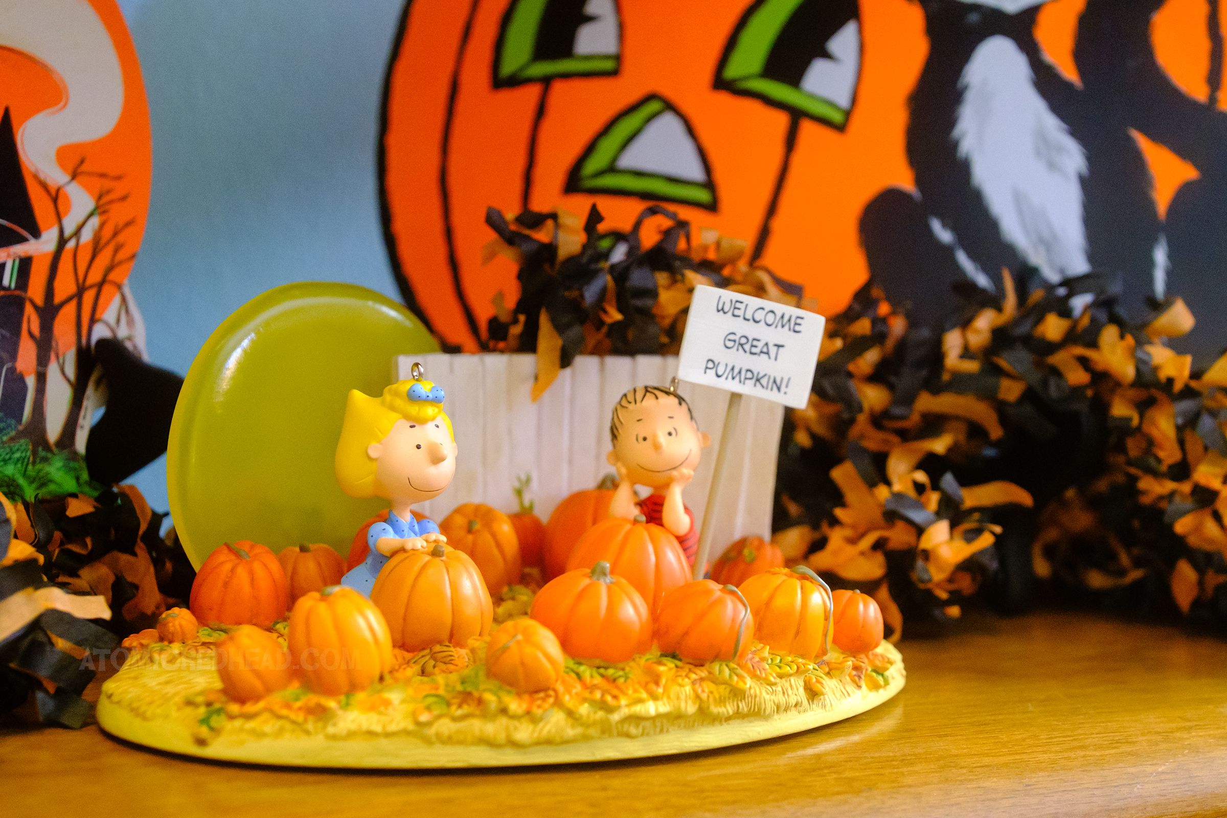 A small figural scene from It's the Great Pumpkin, Charlie Brown, a Sally and Linus sitting in a pumpkin patch, Linus has a sign that reads Welcome Great Pumpkin