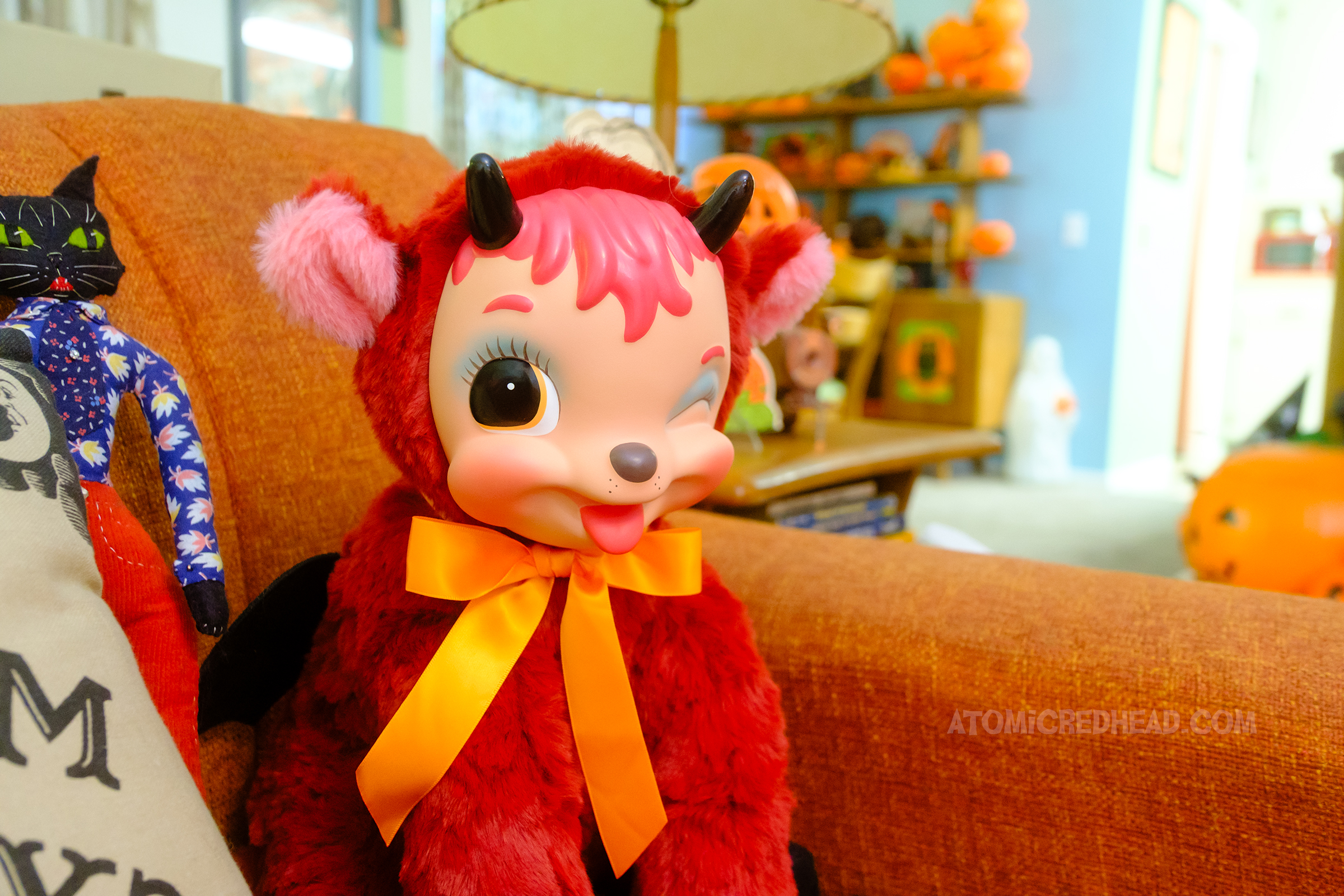Close-up of a red plush goat with a vinyl cartoony face.
