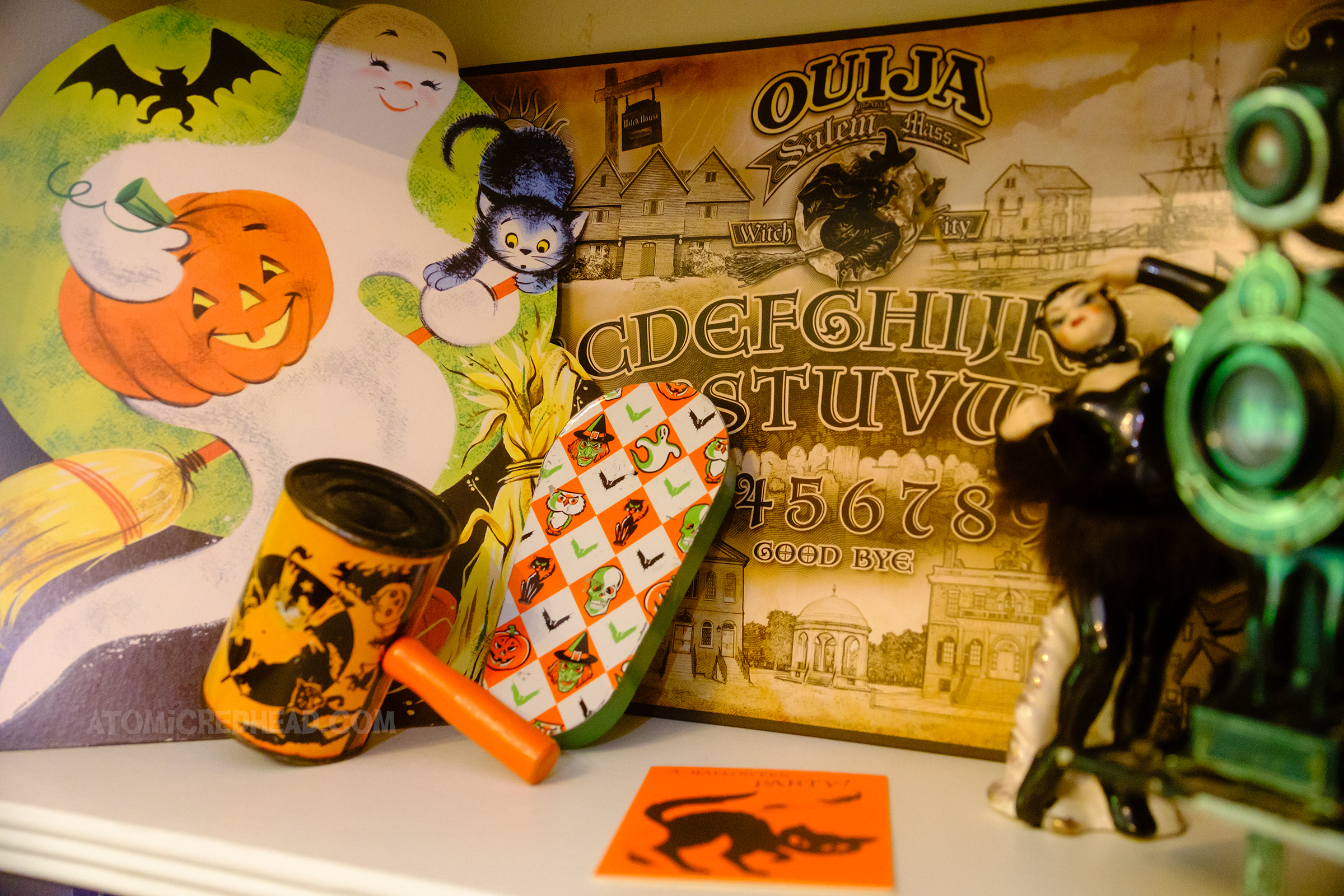 Close-up of a Ouija board themed to Salem, Massachusetts, next to it sits a die cut of a ghost.