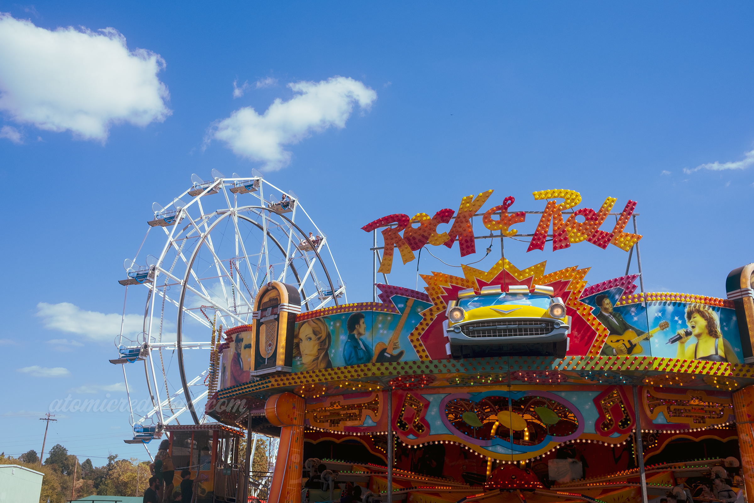 The "Rock & Roll" ride features murals of musicians, a car, and jukeboxes, behind is the ferris wheel.
