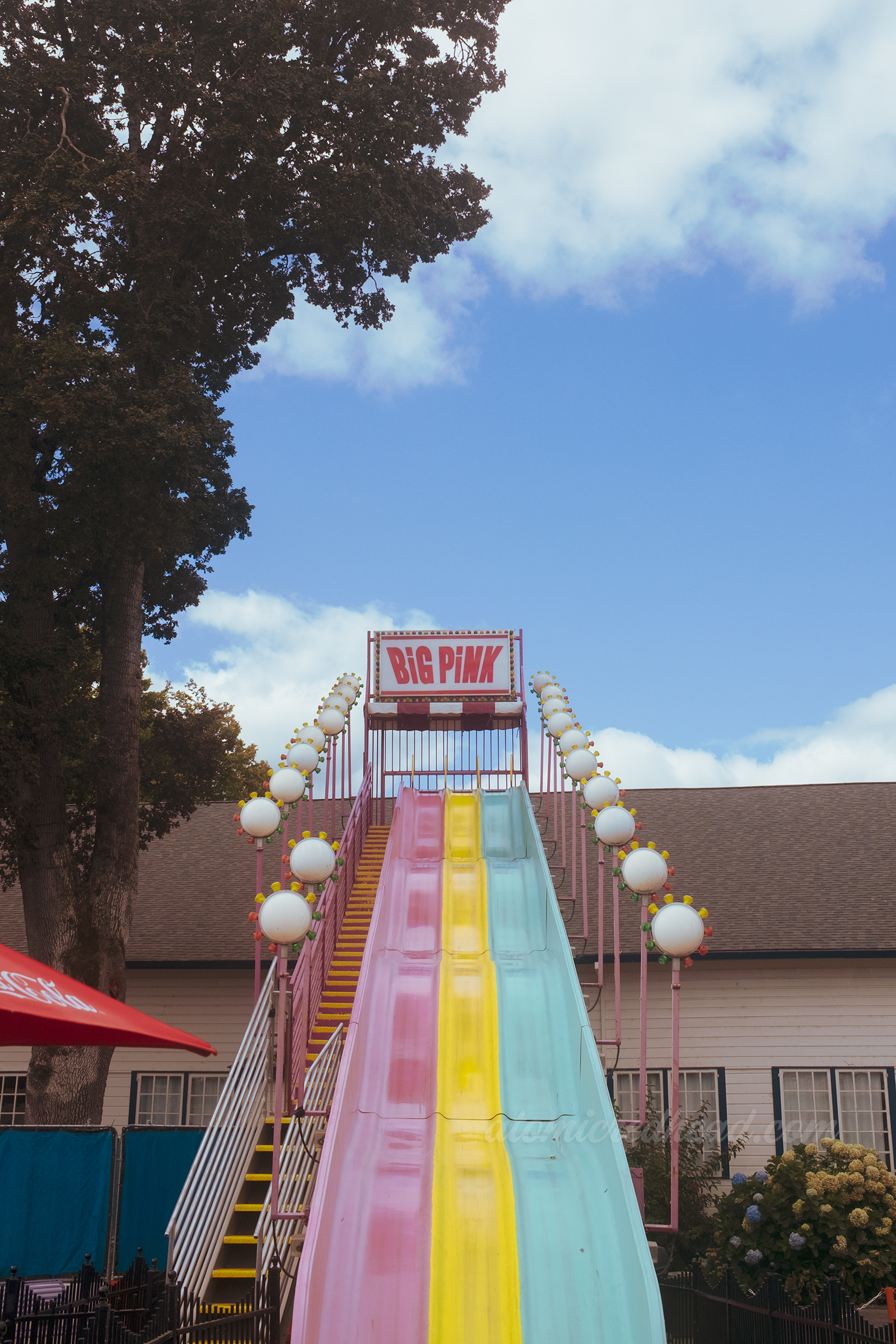 The massive "Big Pink" slide, which rises above the boardwalk and has three slides, one pink, one yellow, and a third in turquoise.