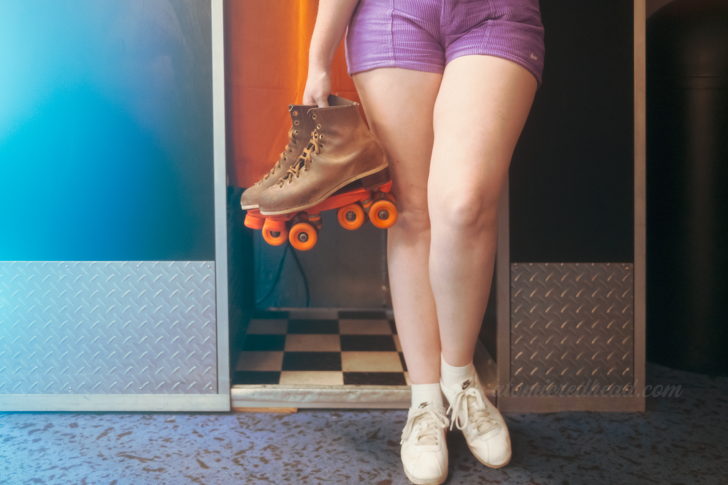My hands holding a pair of rented skates.