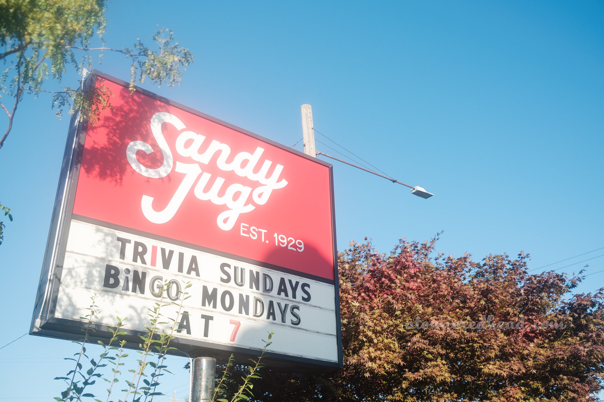 A red sign reads "Sandy Jug Est. 1929"