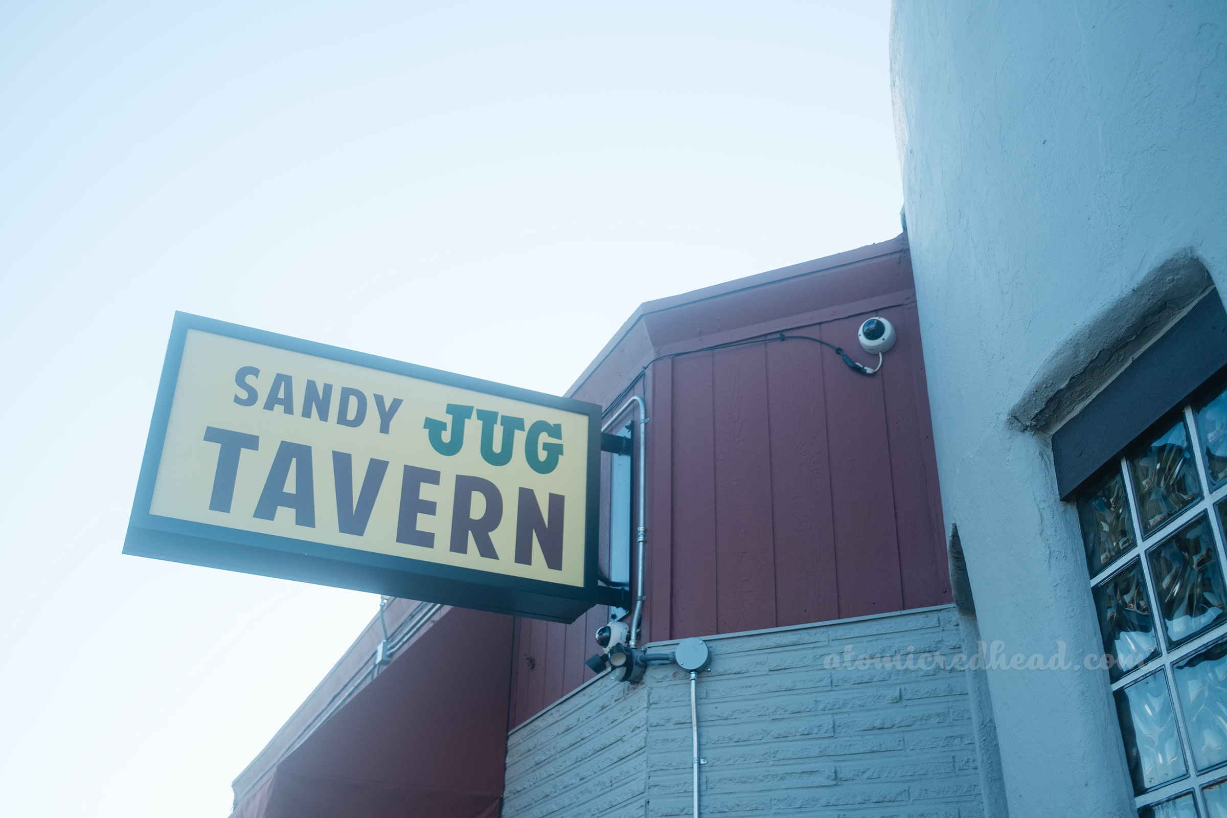 A white sign reads "Sandy Jug Tavern"