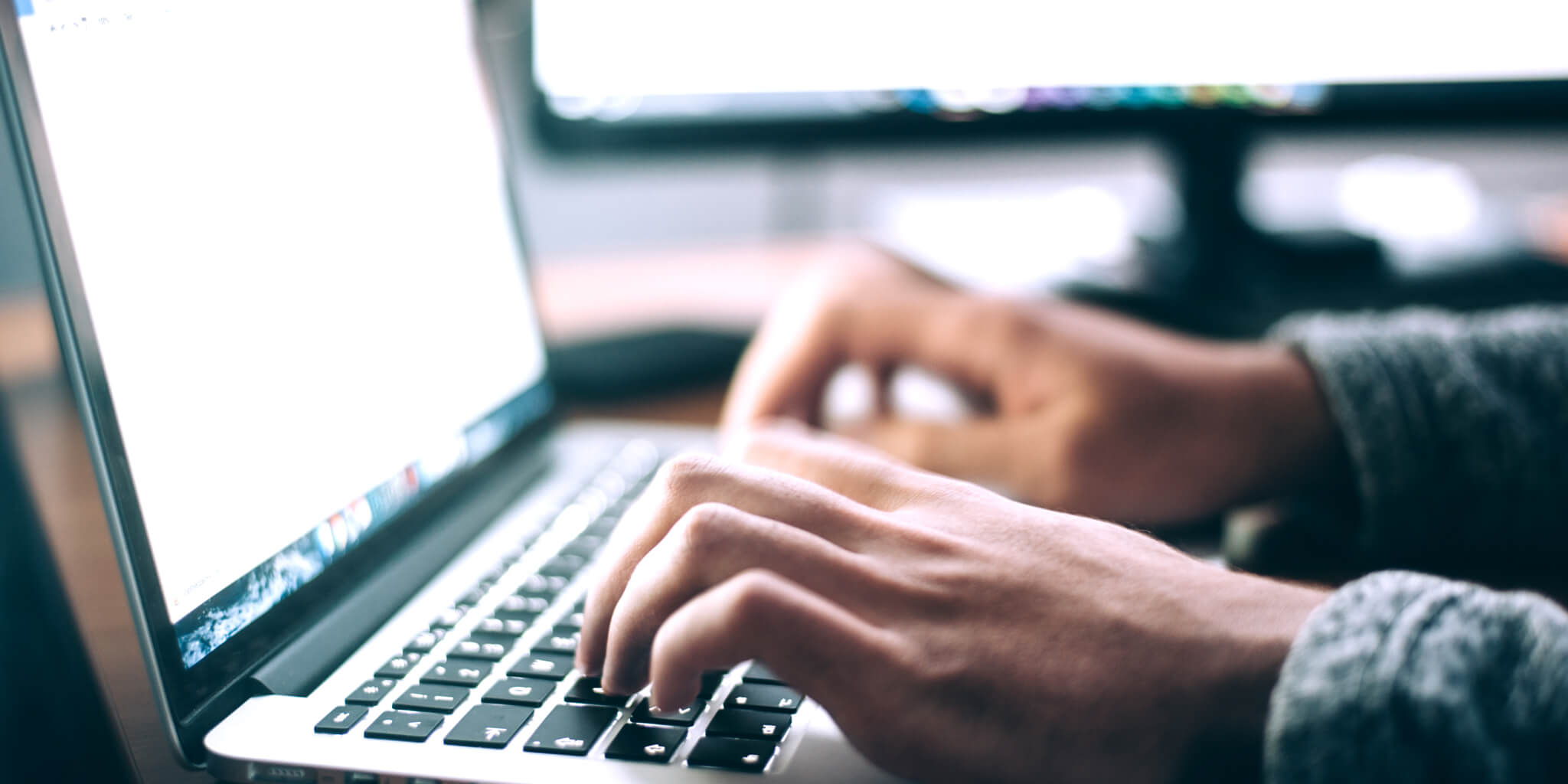 Person typing on laptop keyboard