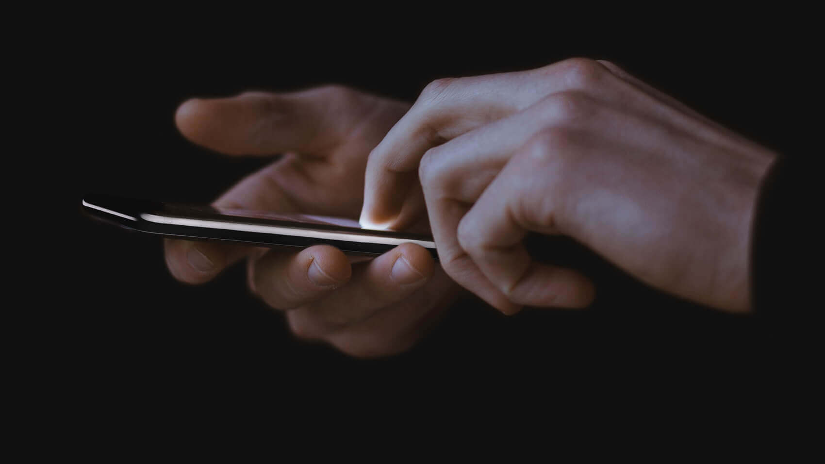 Image on ATTCK.com native apps page. Close up of hands holding an iPhone.