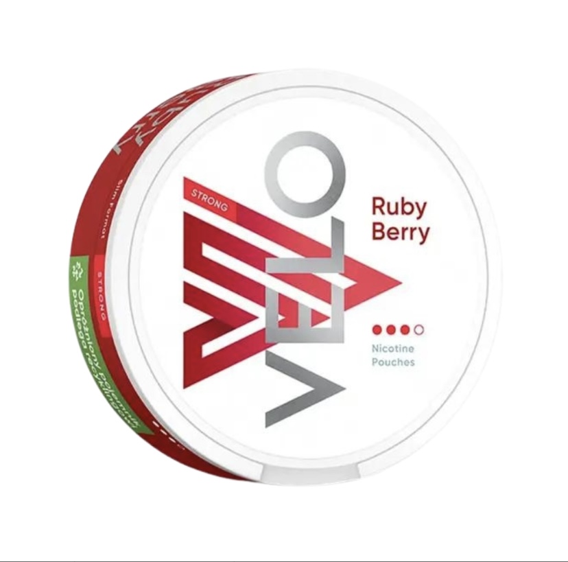 Round white tin labeled Velo Ruby Berry nicotine pouches, featuring a red geometric logo and flavor name on the lid.