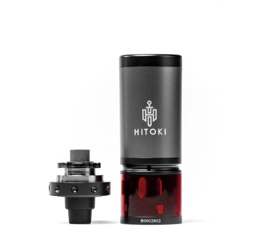 Hitoki vaporizer component with a red translucent chamber and gray top, shown beside its detachable base.